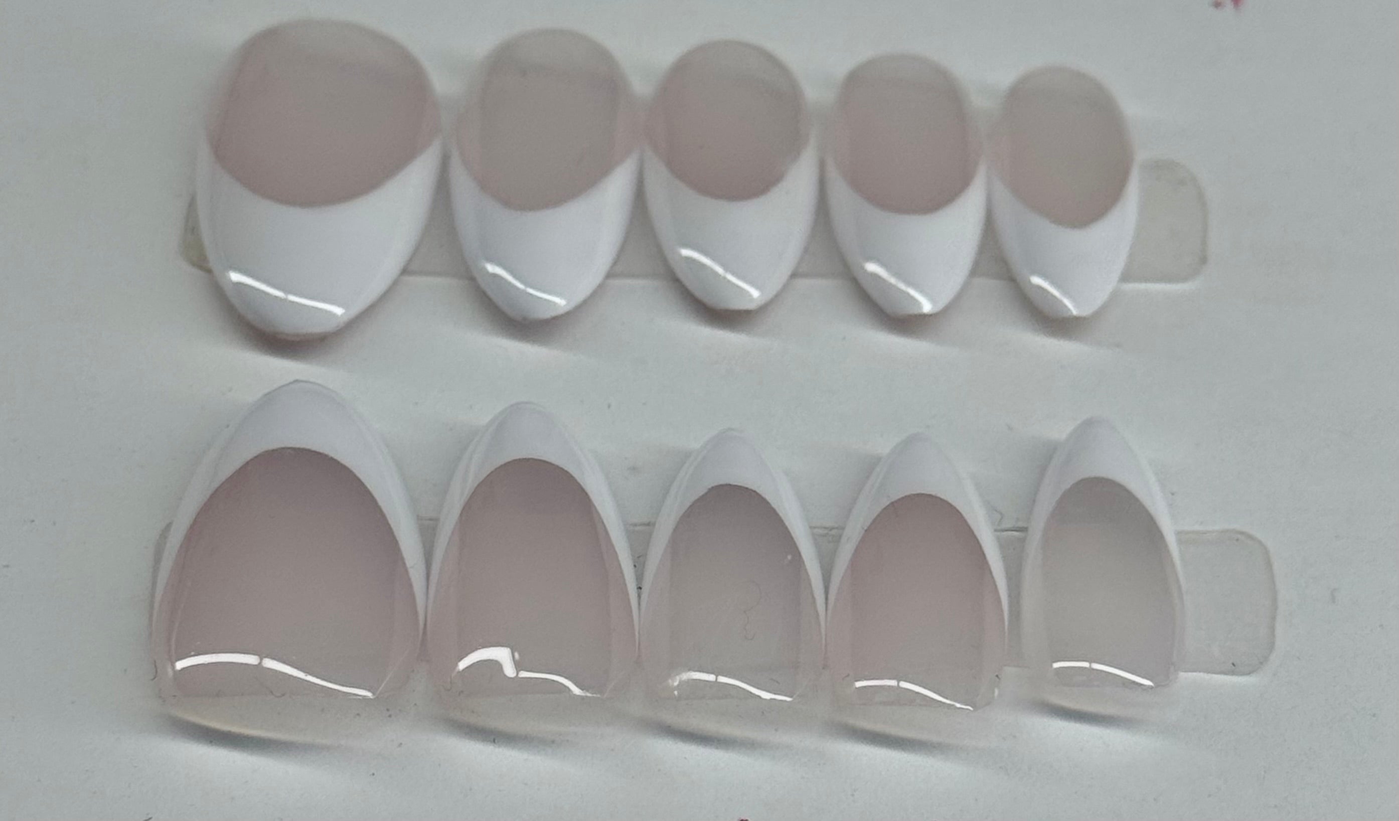 Set of white nail tips on a gray background