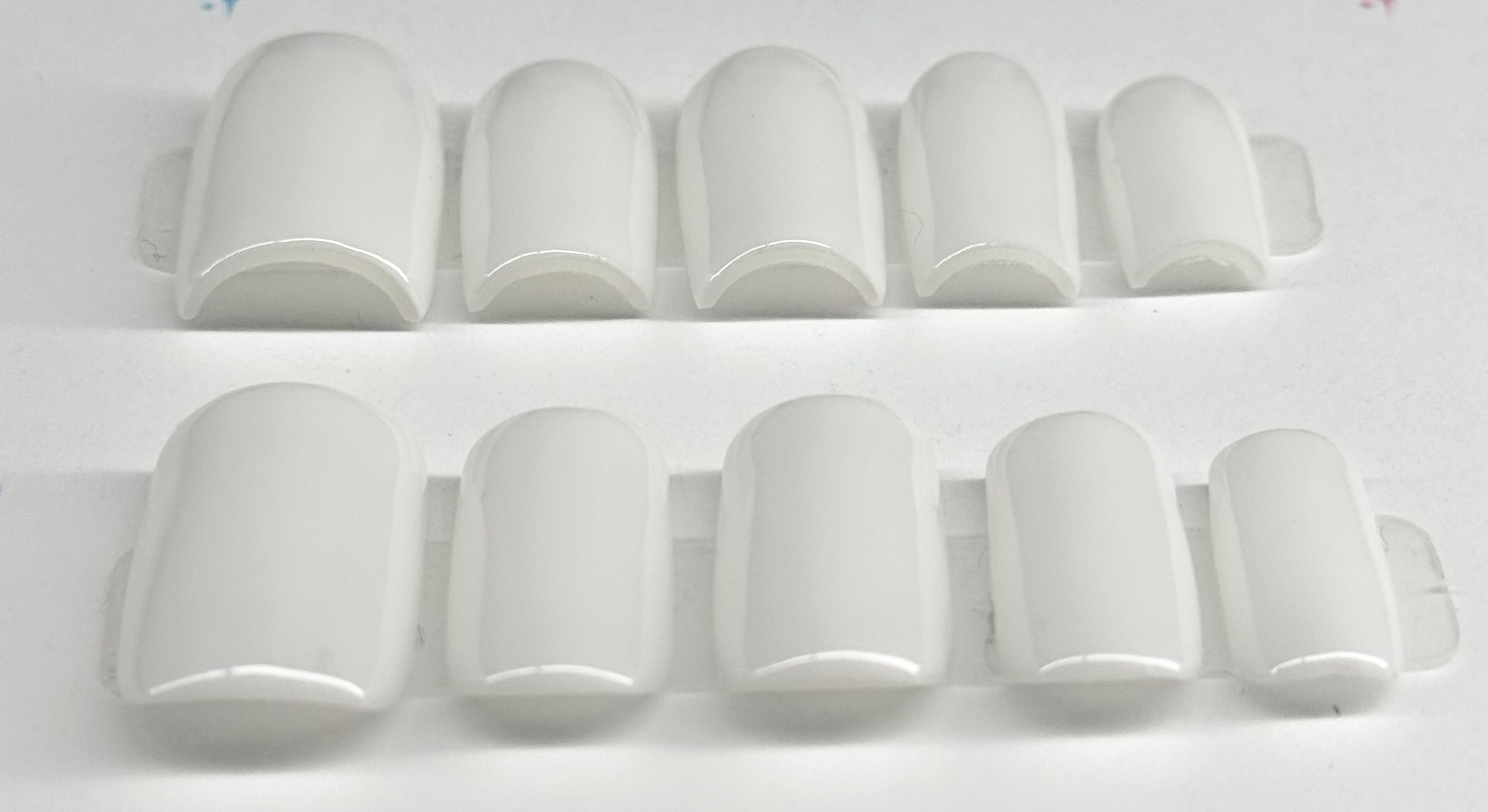 Set of white nail caps on a white background