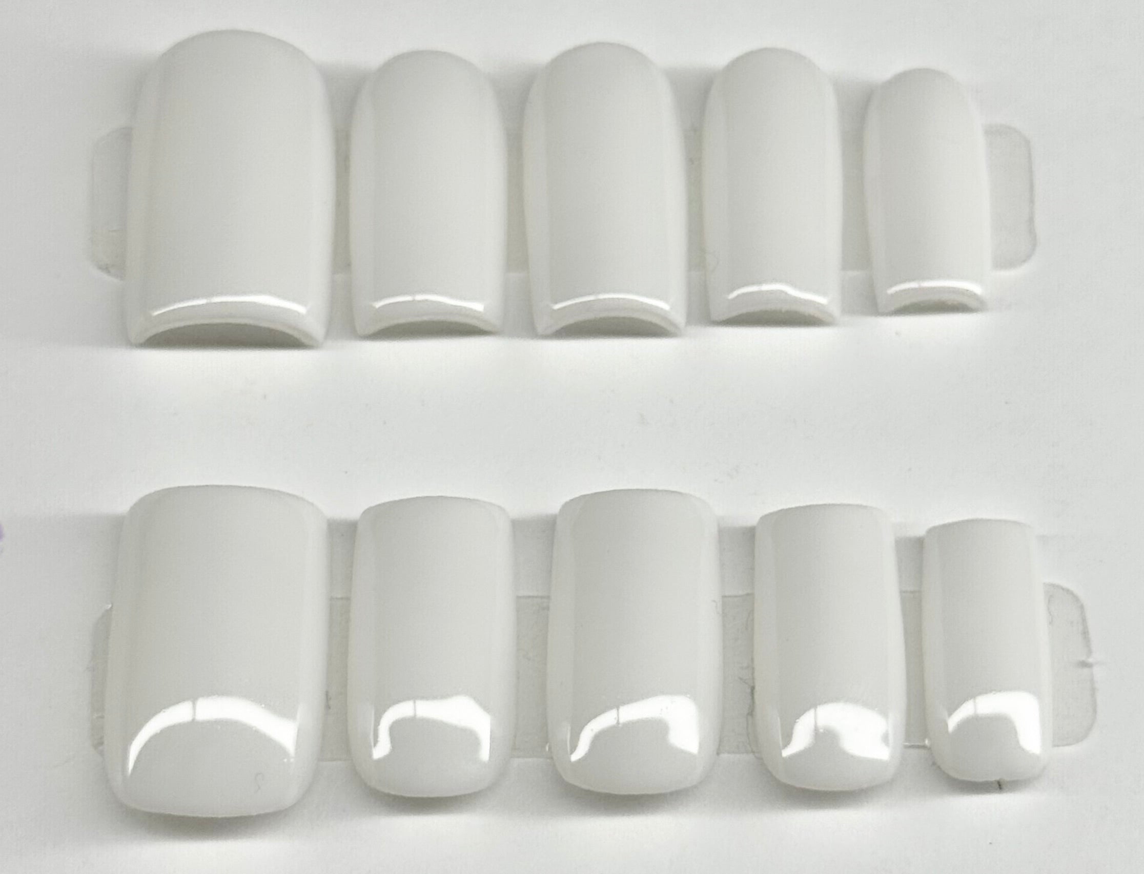 Set of white nail tips on a white background