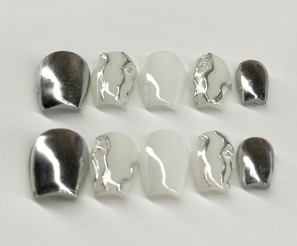 Set of silver and white ceramic pieces on a light gray background