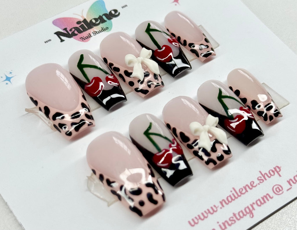 Decorative false nails with animal print and red heart designs on a Nailene branded card.