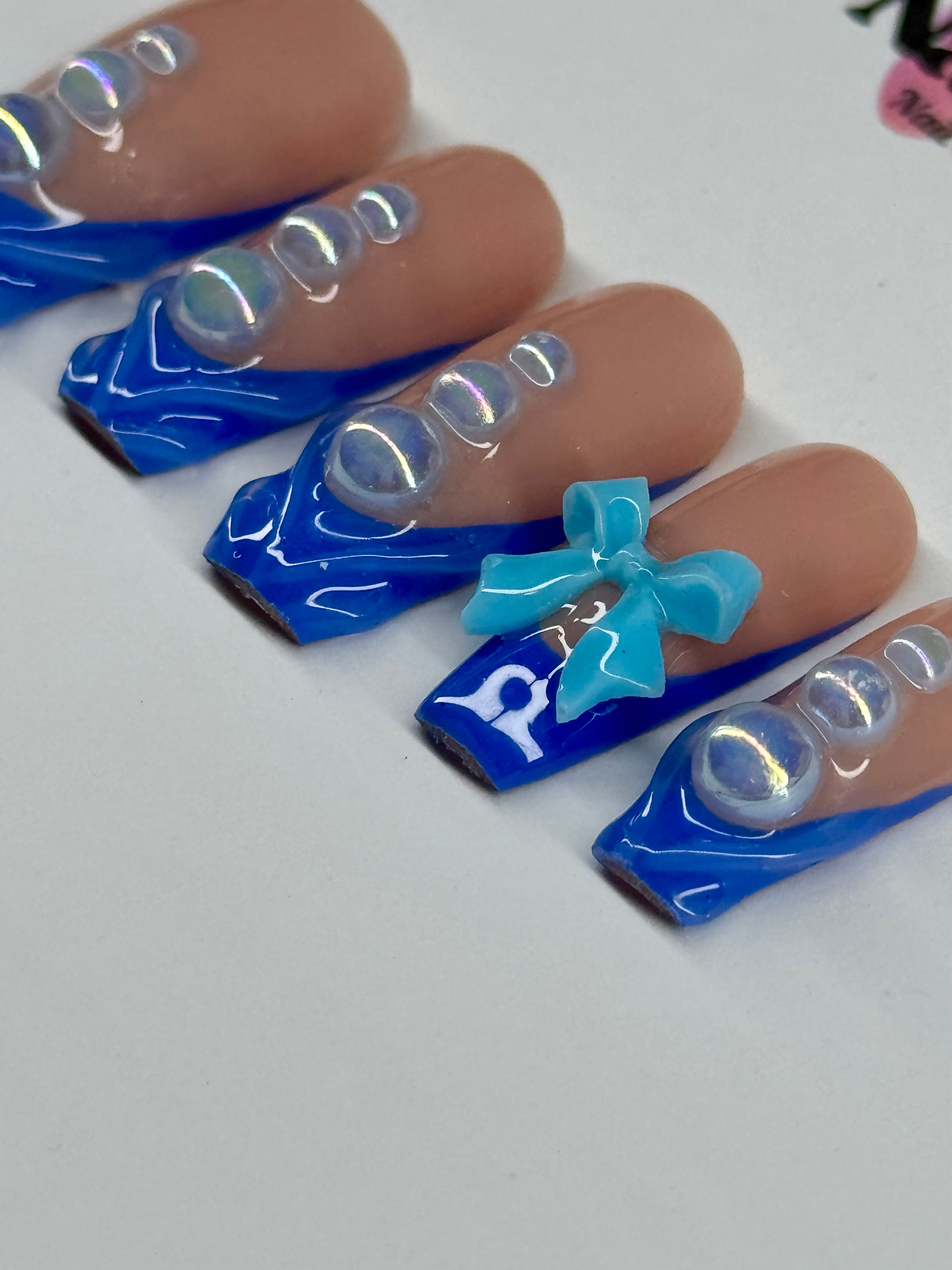 Nails with blue and clear design on a white background
