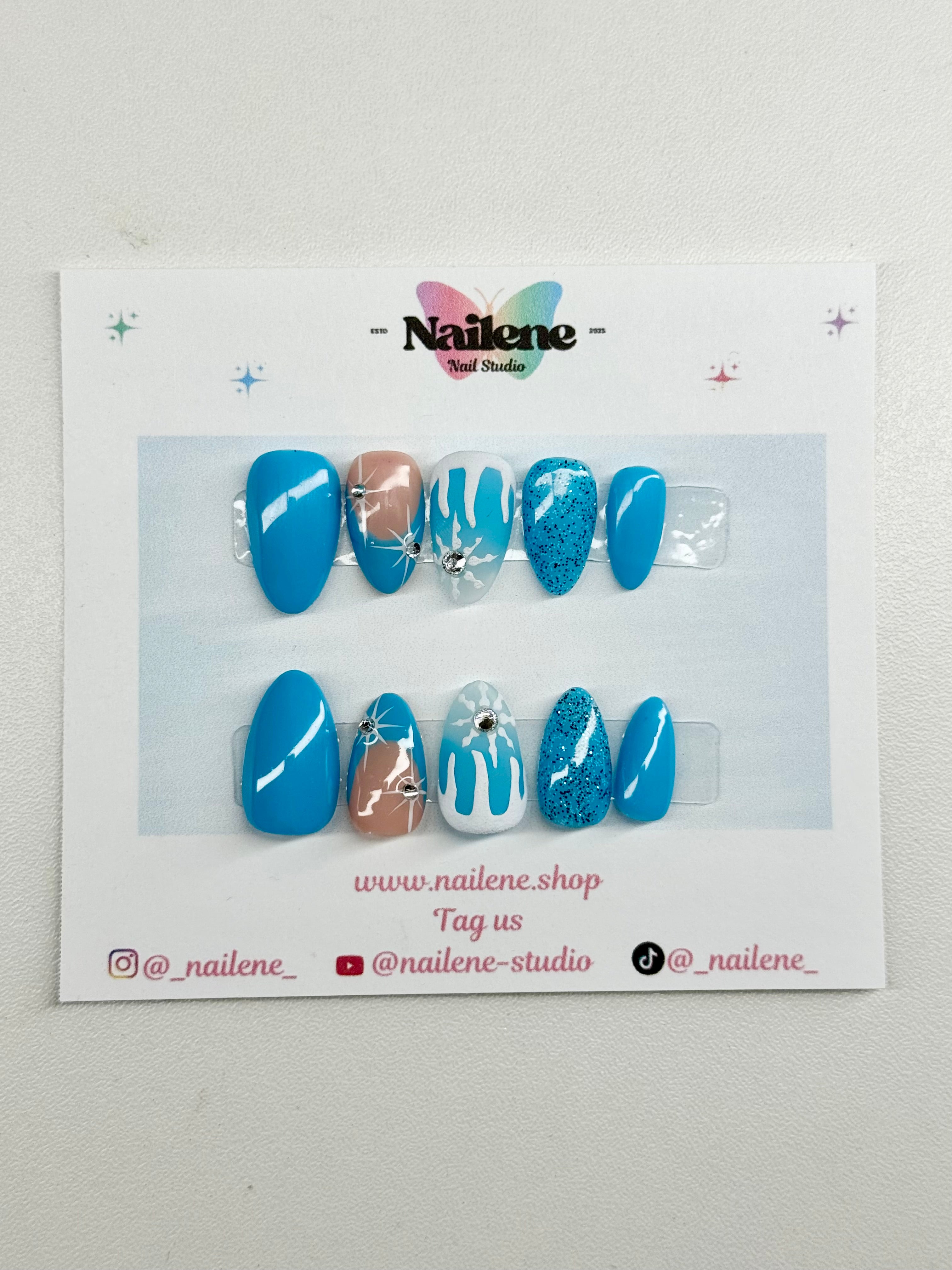 Set of blue and white nail art designs on a display card with Nailene branding.