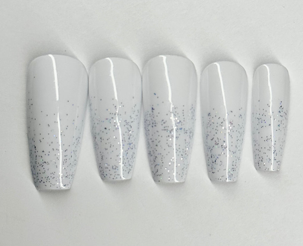Set of five white nail polish with glittery specks on a light gray background