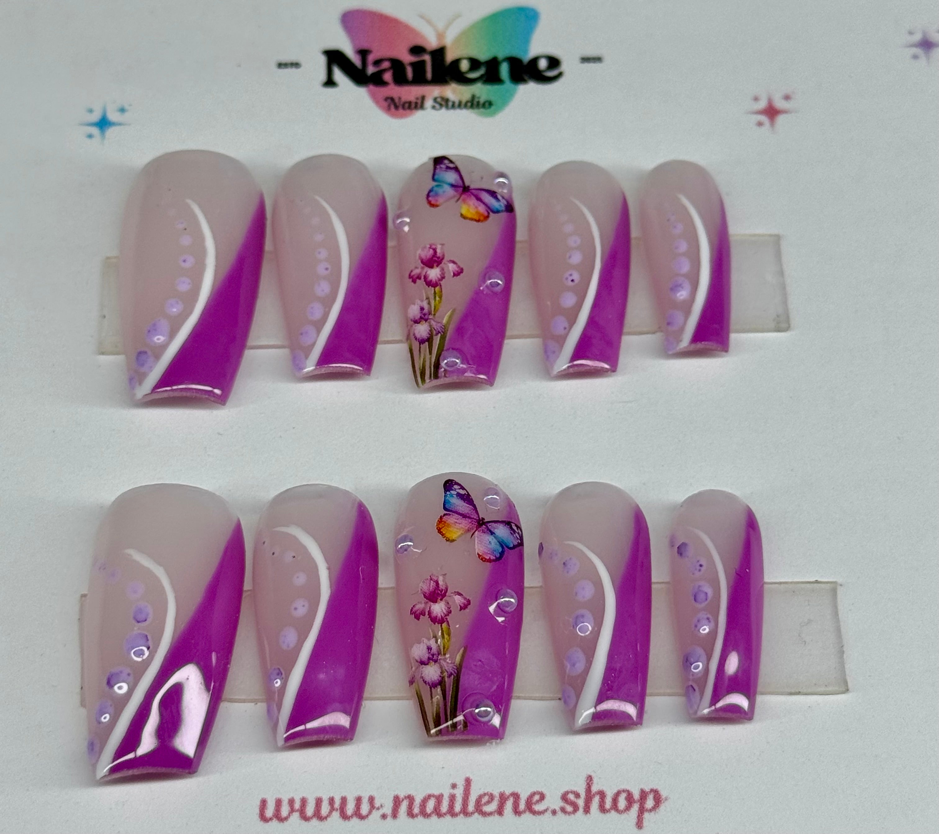 Set of decorative nail extensions with floral and butterfly designs on a white background, branded 'Nailene'.