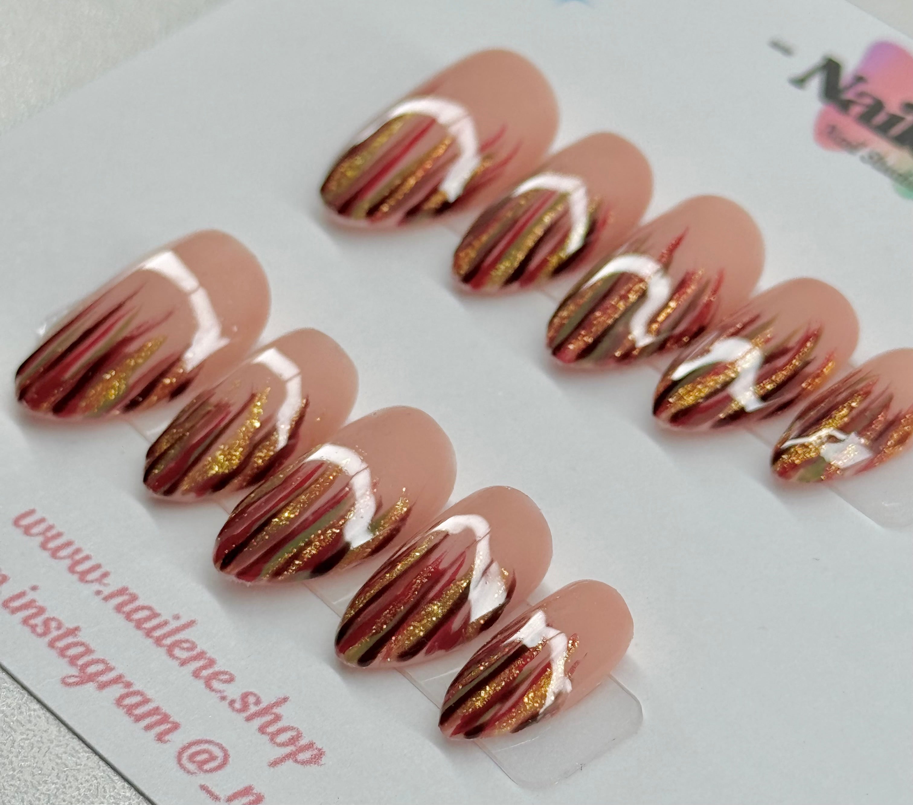 Nail art design with gold and white accents on a clear background