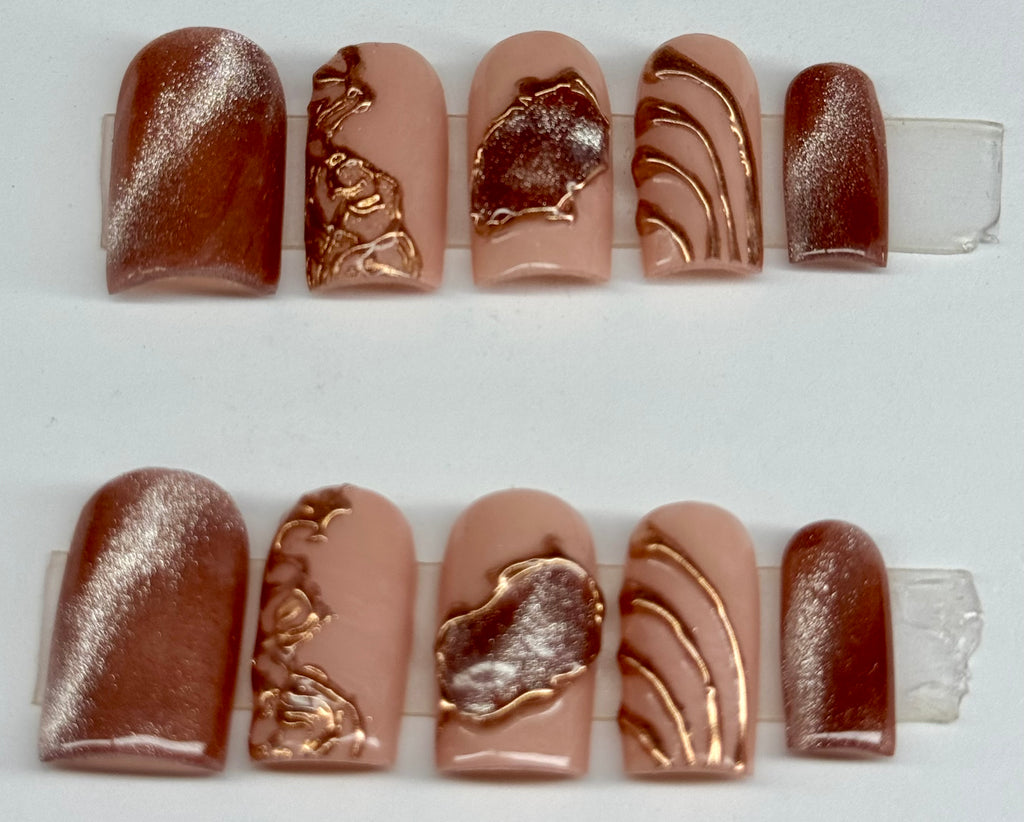 Set of nail art samples with metallic designs on a white background