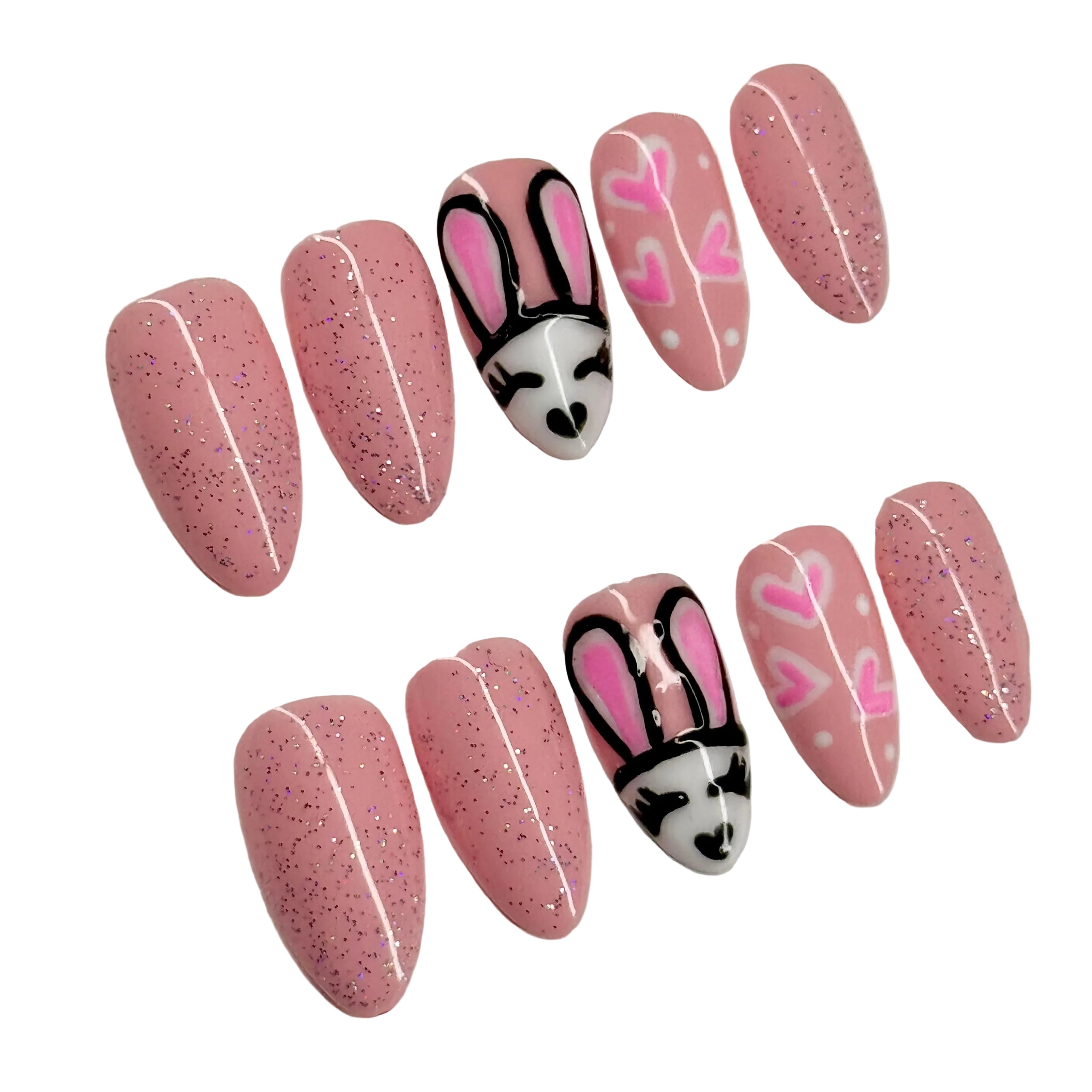 Set of pink glittery nails with bunny designs on a white background