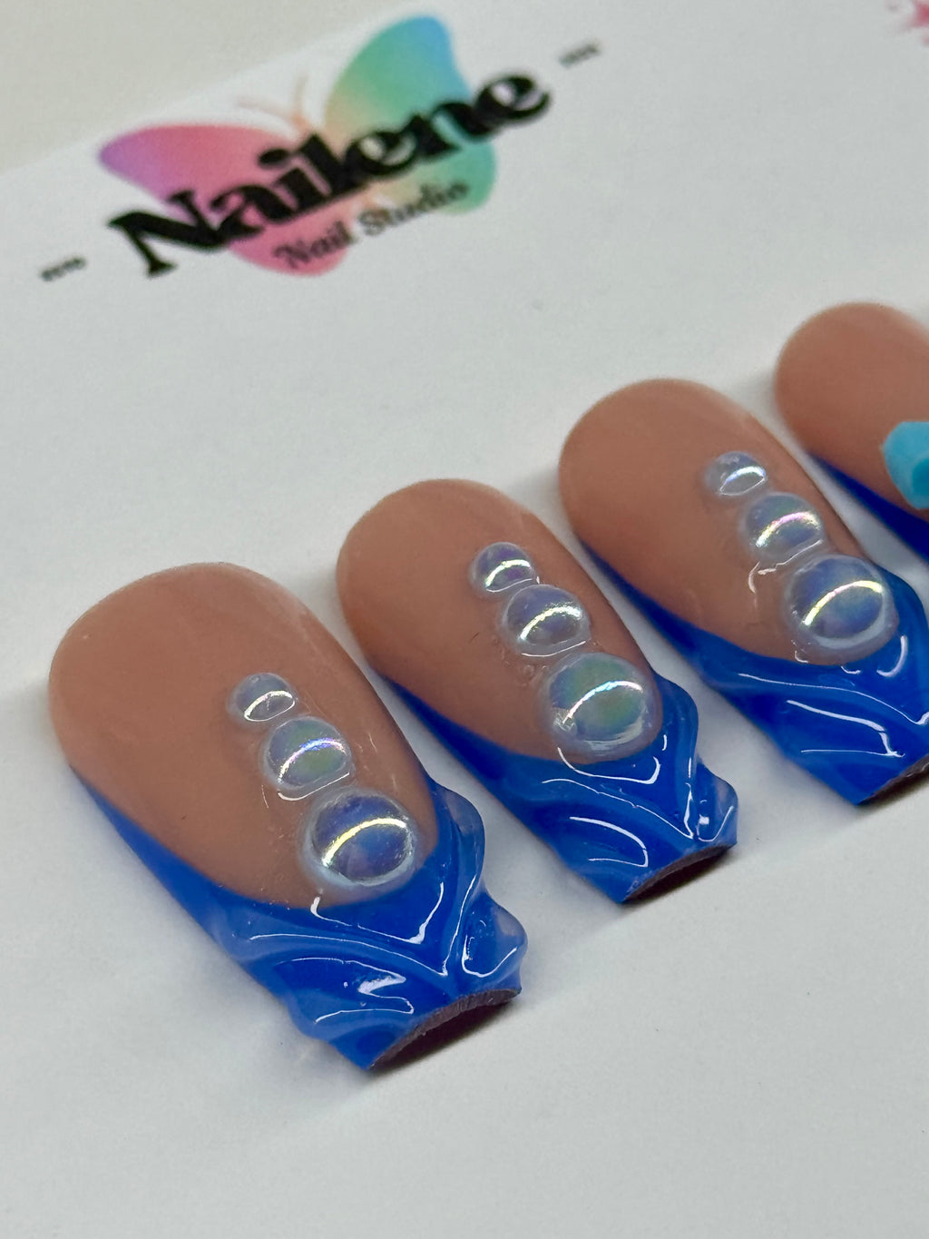 Nail art design with blue and silver accents on a white background with 'Nailene' branding.