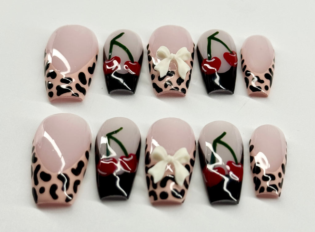 Set of nail art designs with leopard print, bows, and cherries on a light background