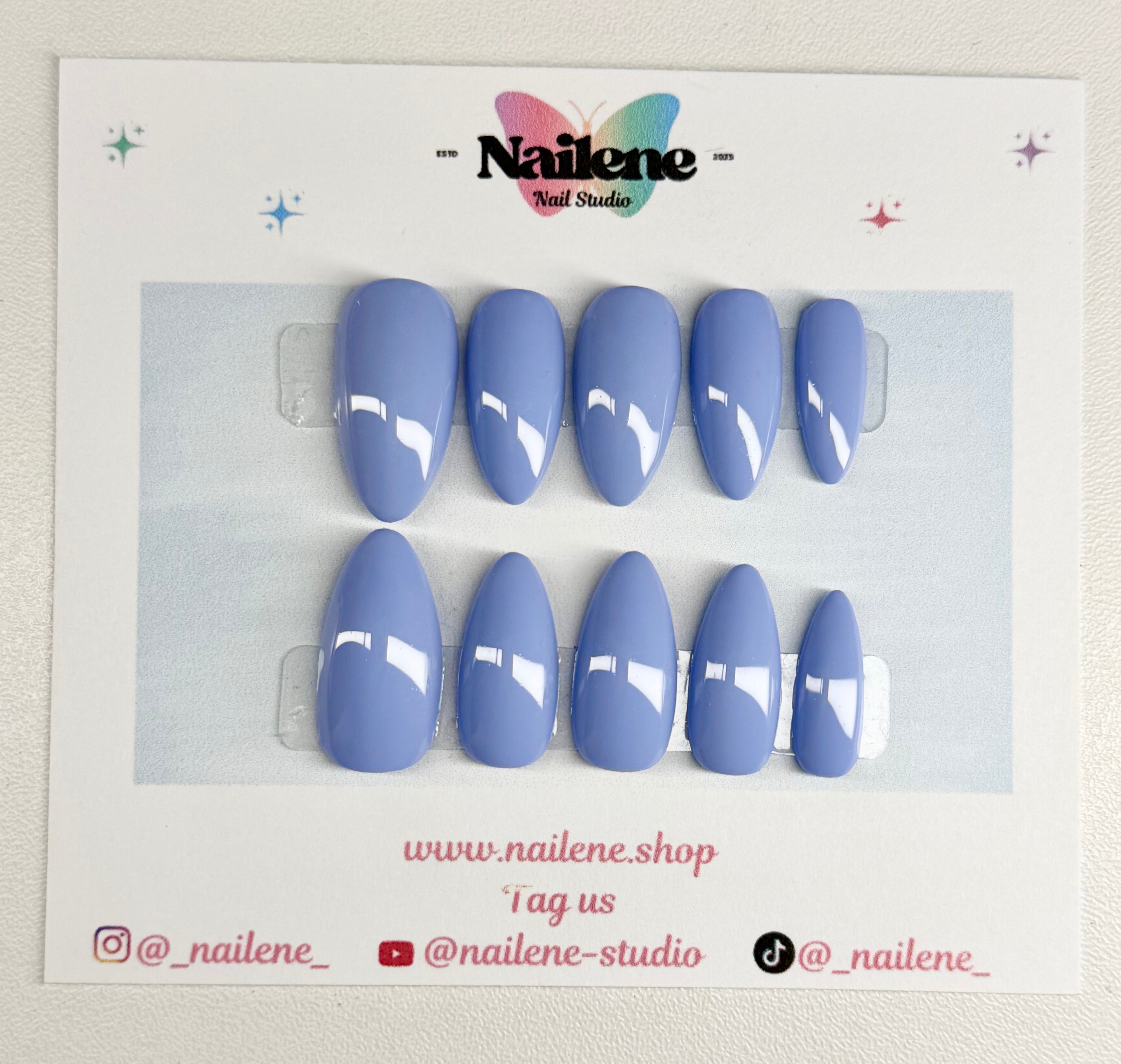 Set of blue nail tips on a branded card with Nailene Studio logo.