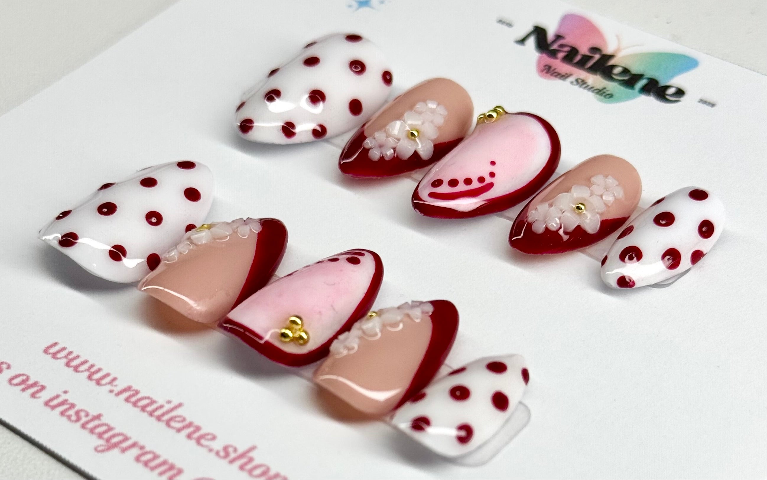Set of decorative nail art pieces with polka dots and floral designs on a white background.