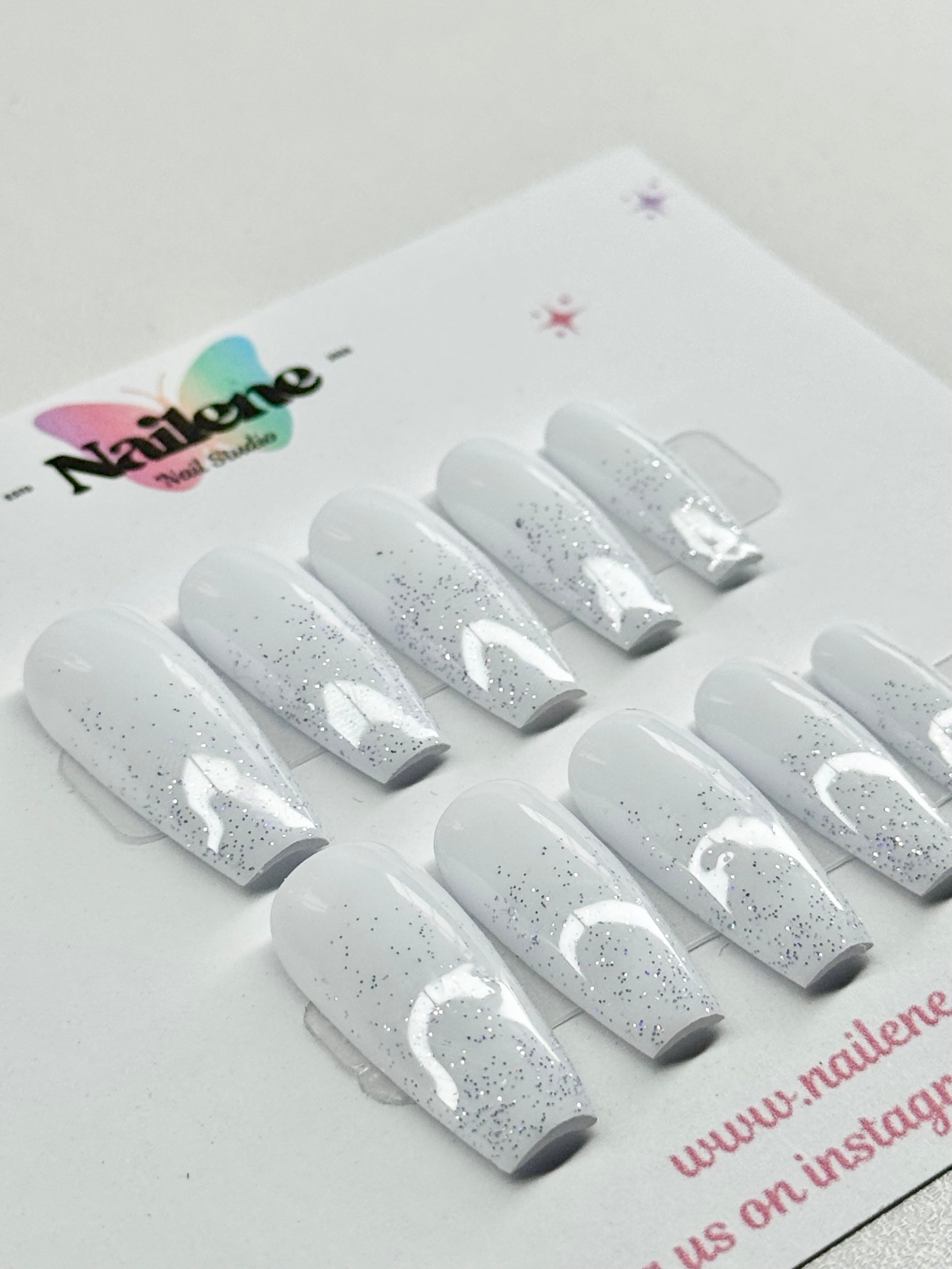 Set of gray glittery nail extensions on a NaiLene branded card.