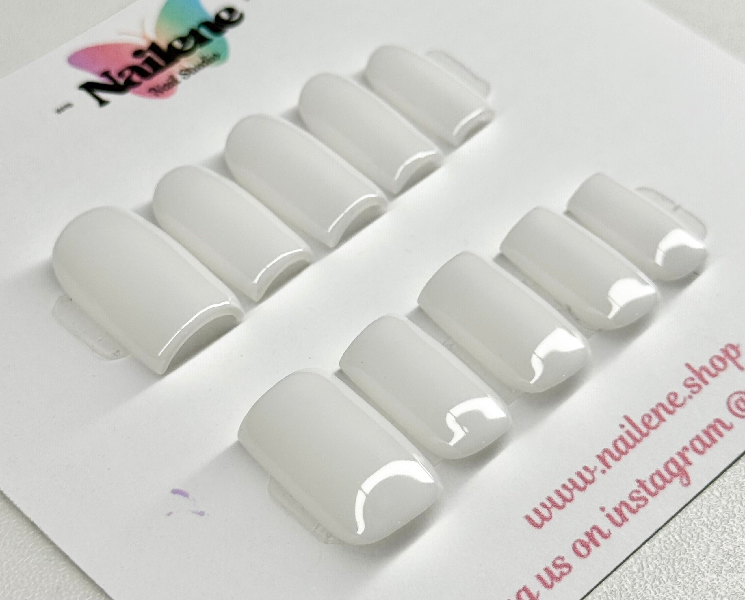 Set of white nail tips on a branded tray with 'Nailene' logo.