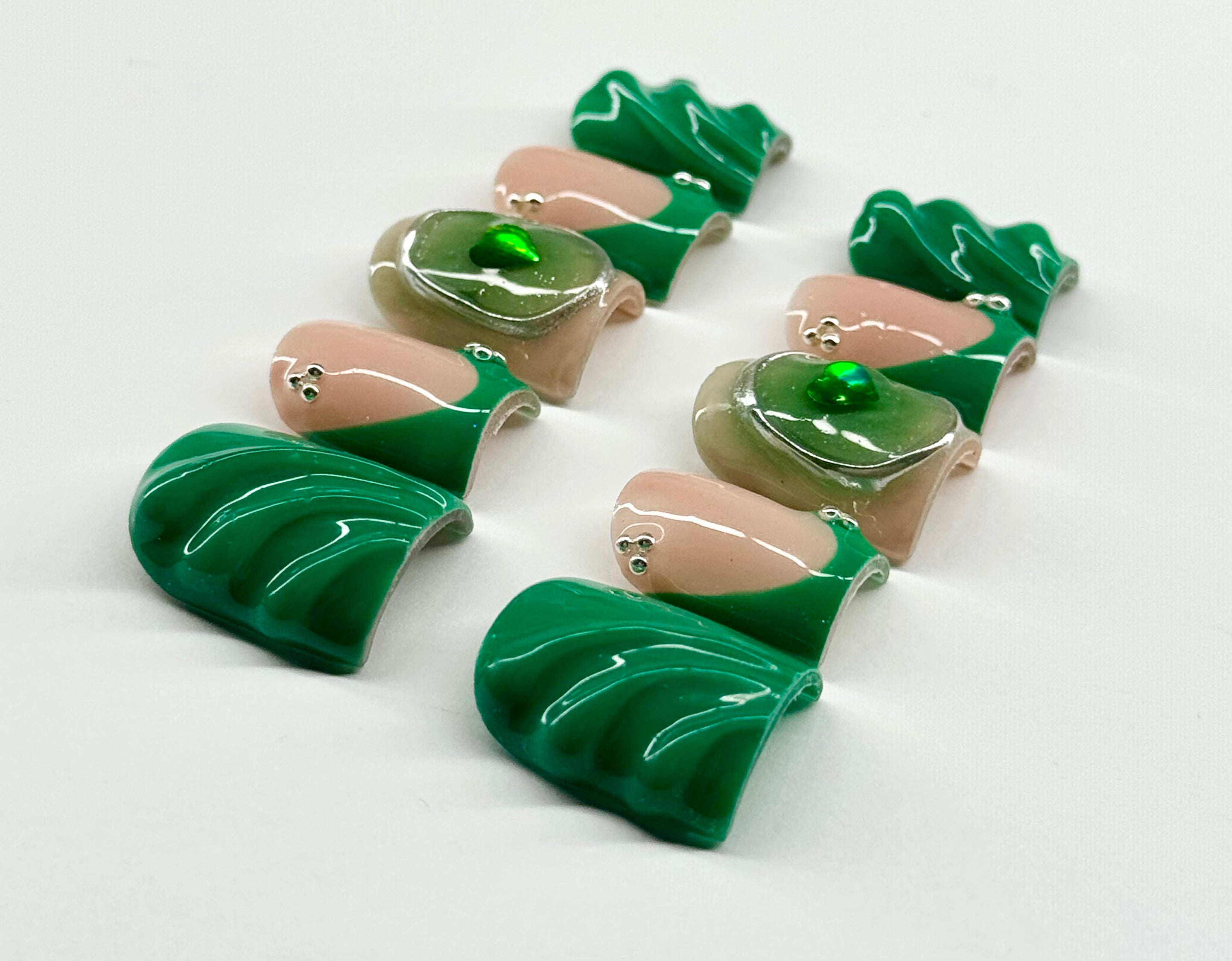 Set of green and beige ceramic leaf-shaped pieces on a white background
