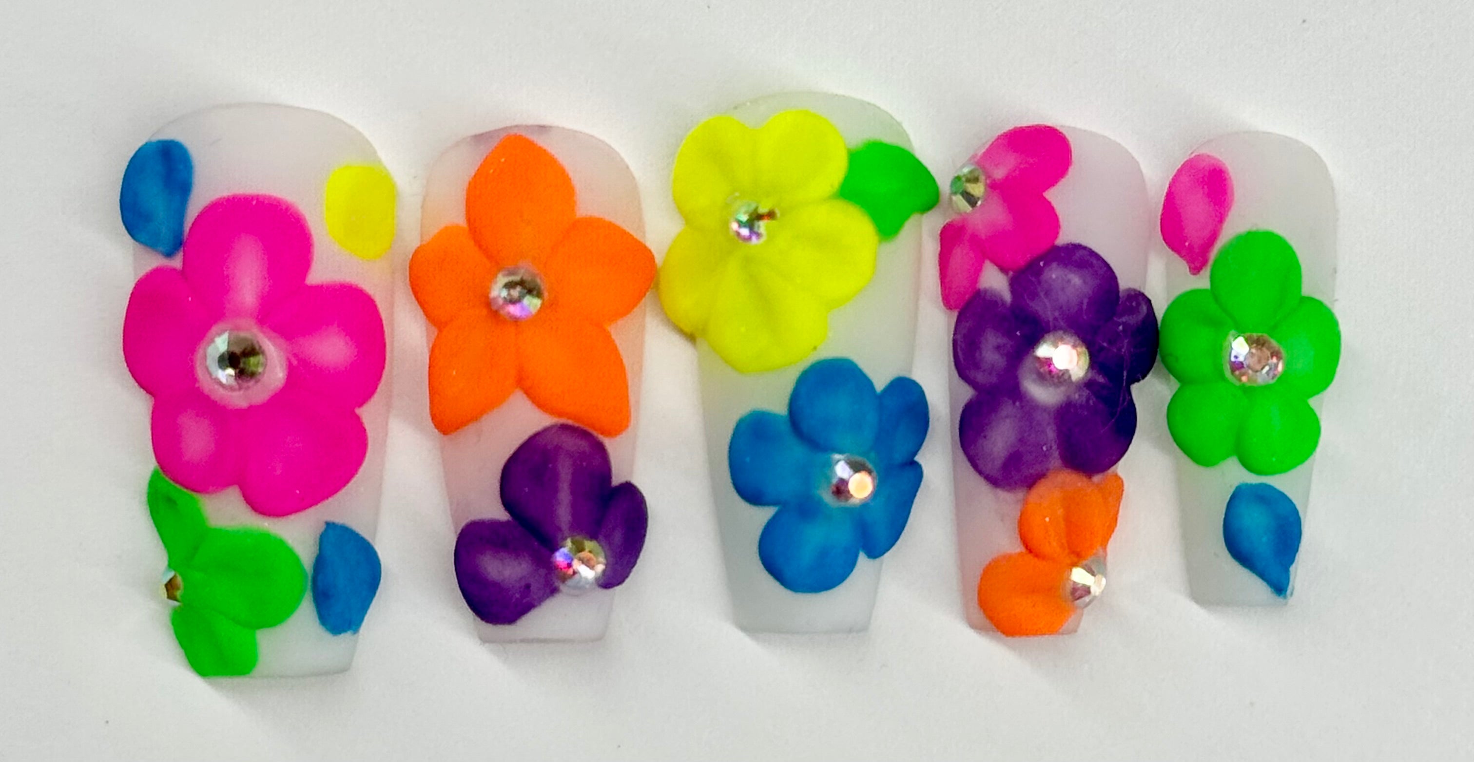 Colorful flower-shaped nail art decorations on a white background