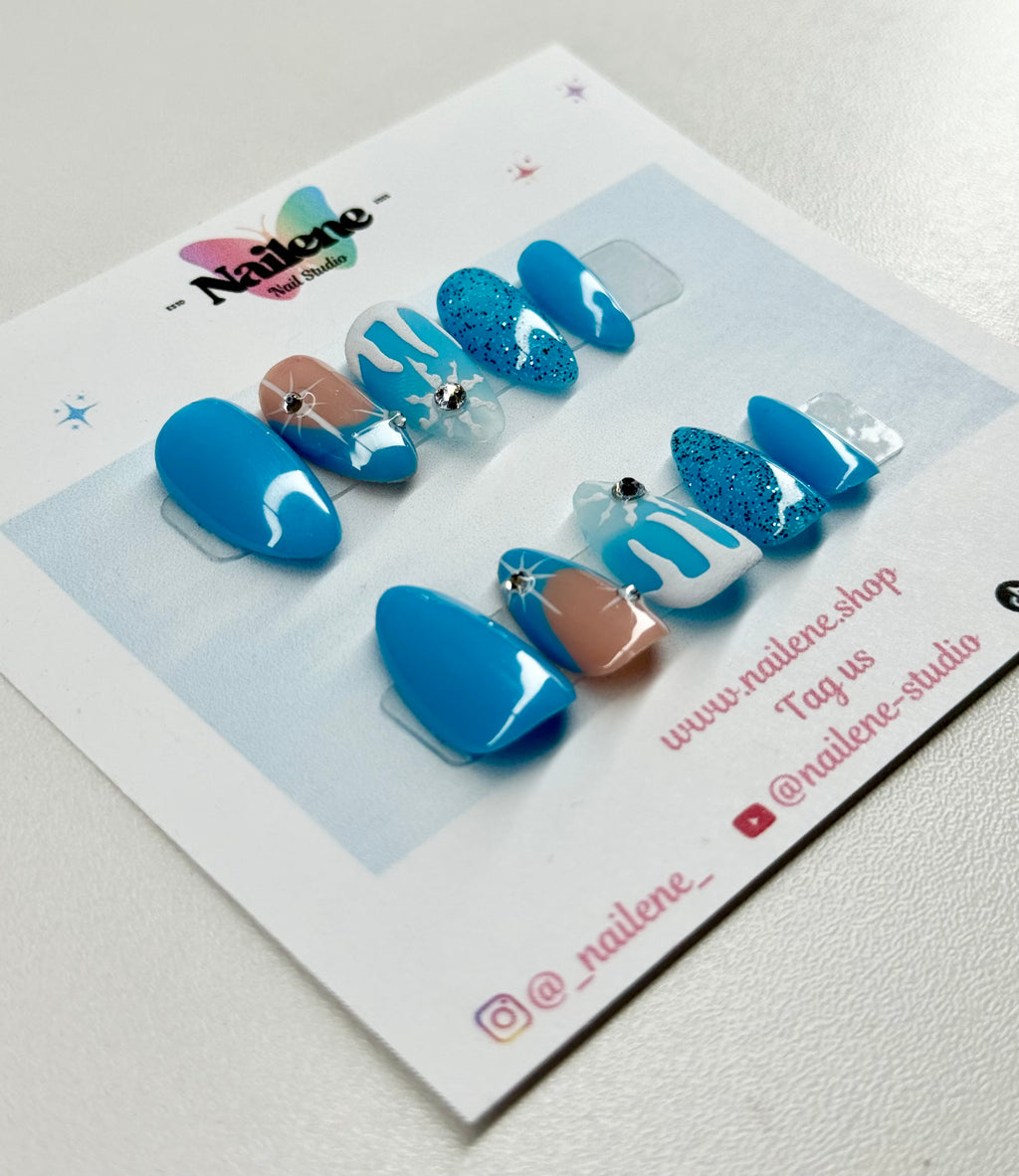 Set of blue and white nail art designs on a display card with Nailene branding.