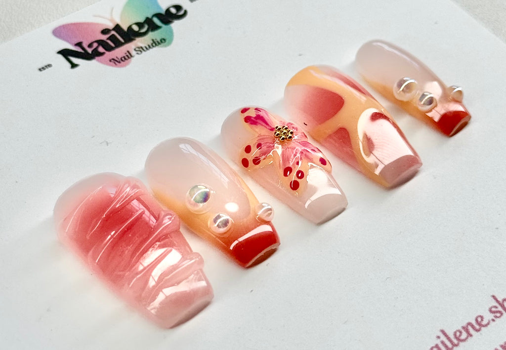 Decorative false nails with pink and red design on a Nailene branded card.