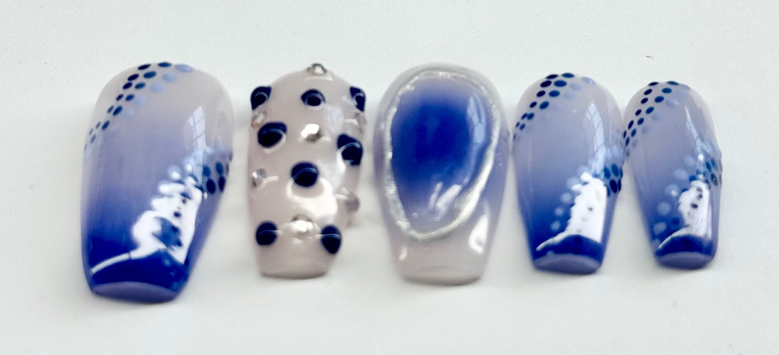 Set of nail designs with blue and silver patterns on a white background