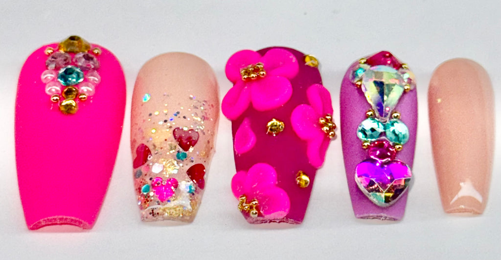 Colorful nail art with flowers and heart designs on a white background