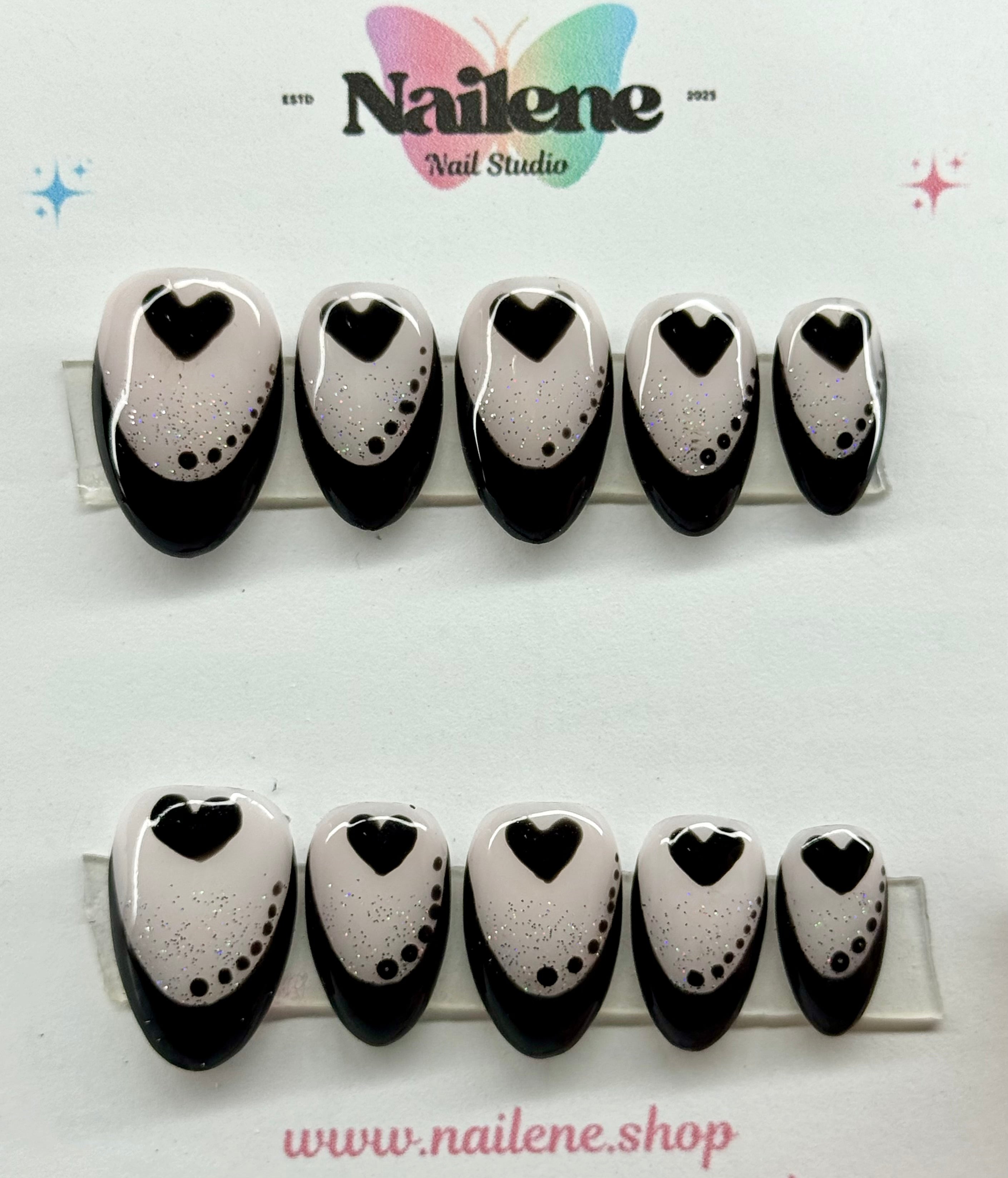Nail art design with black and white hearts on a white background, featuring Nailene Nail Studio branding.