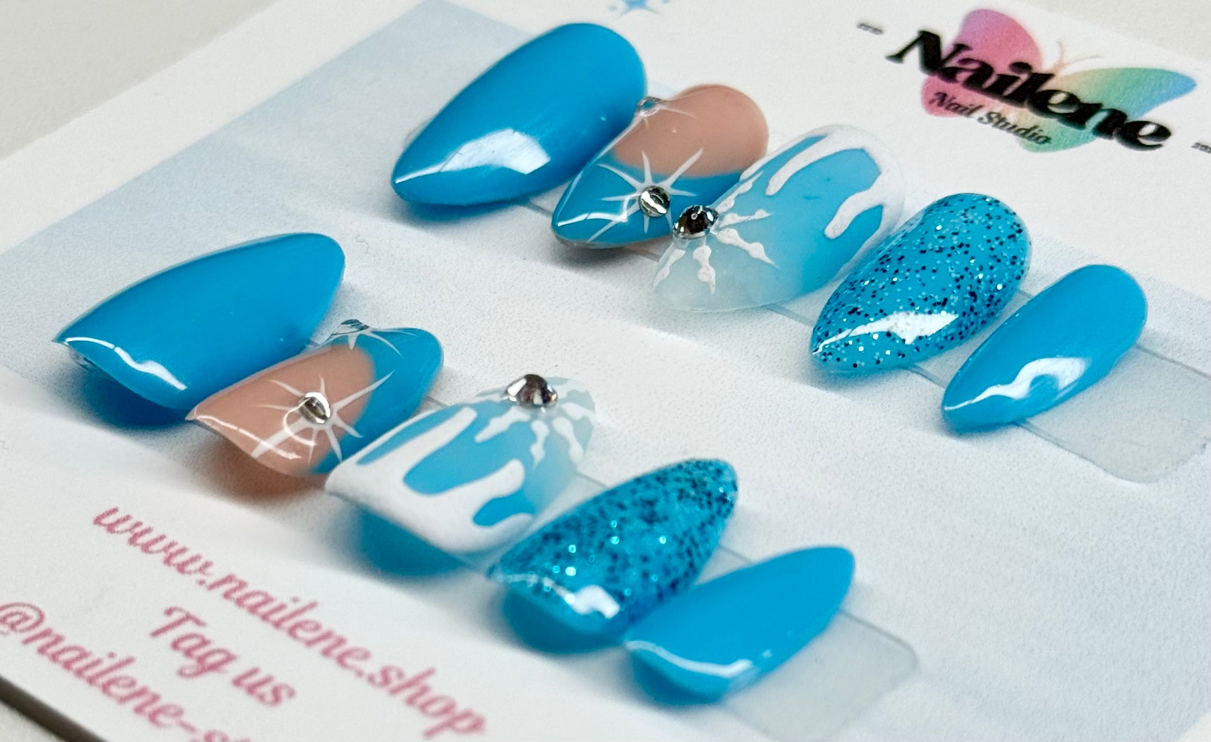 Set of blue and white nail art designs on a white background with 'Nailene' branding.