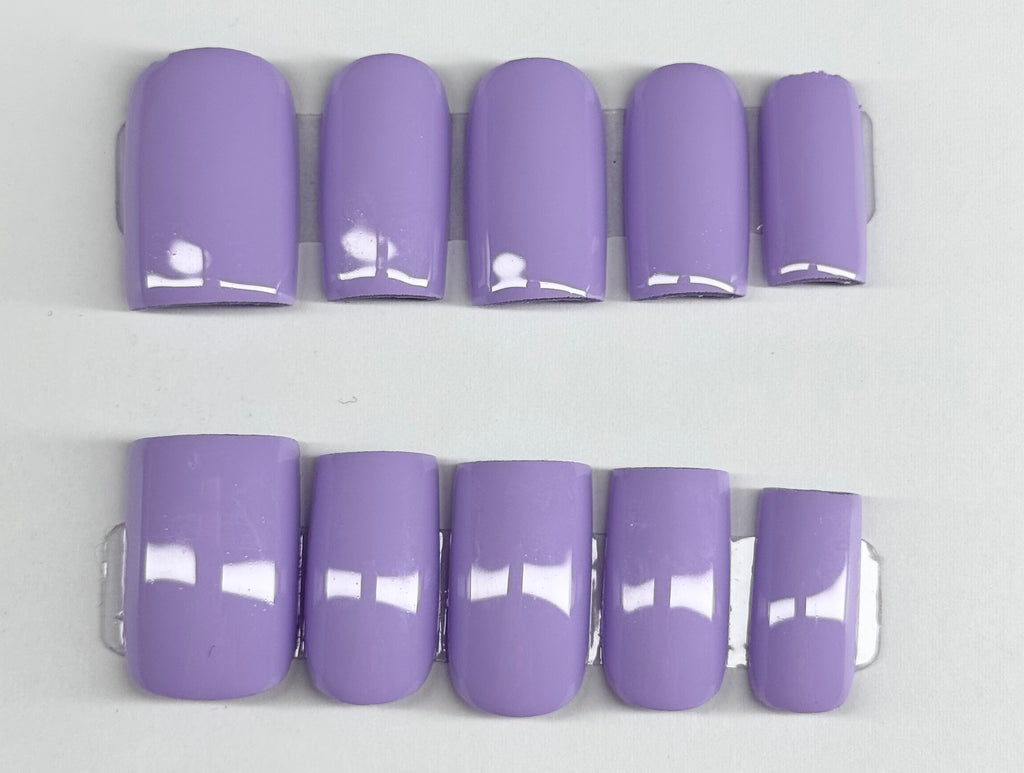 Set of purple nail extensions on a white background