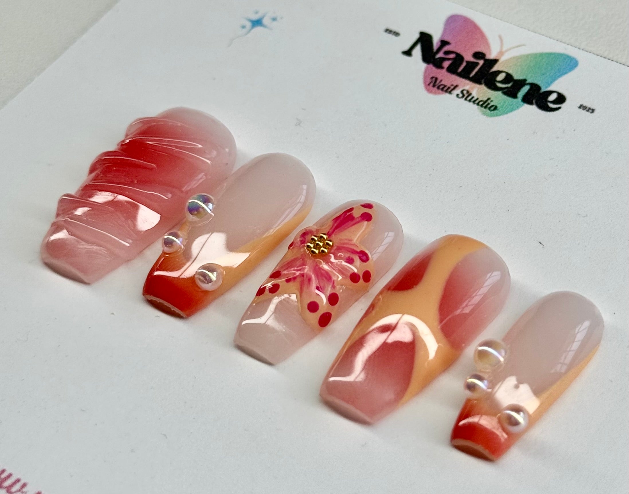 Set of decorative false nails with a brand logo in the background