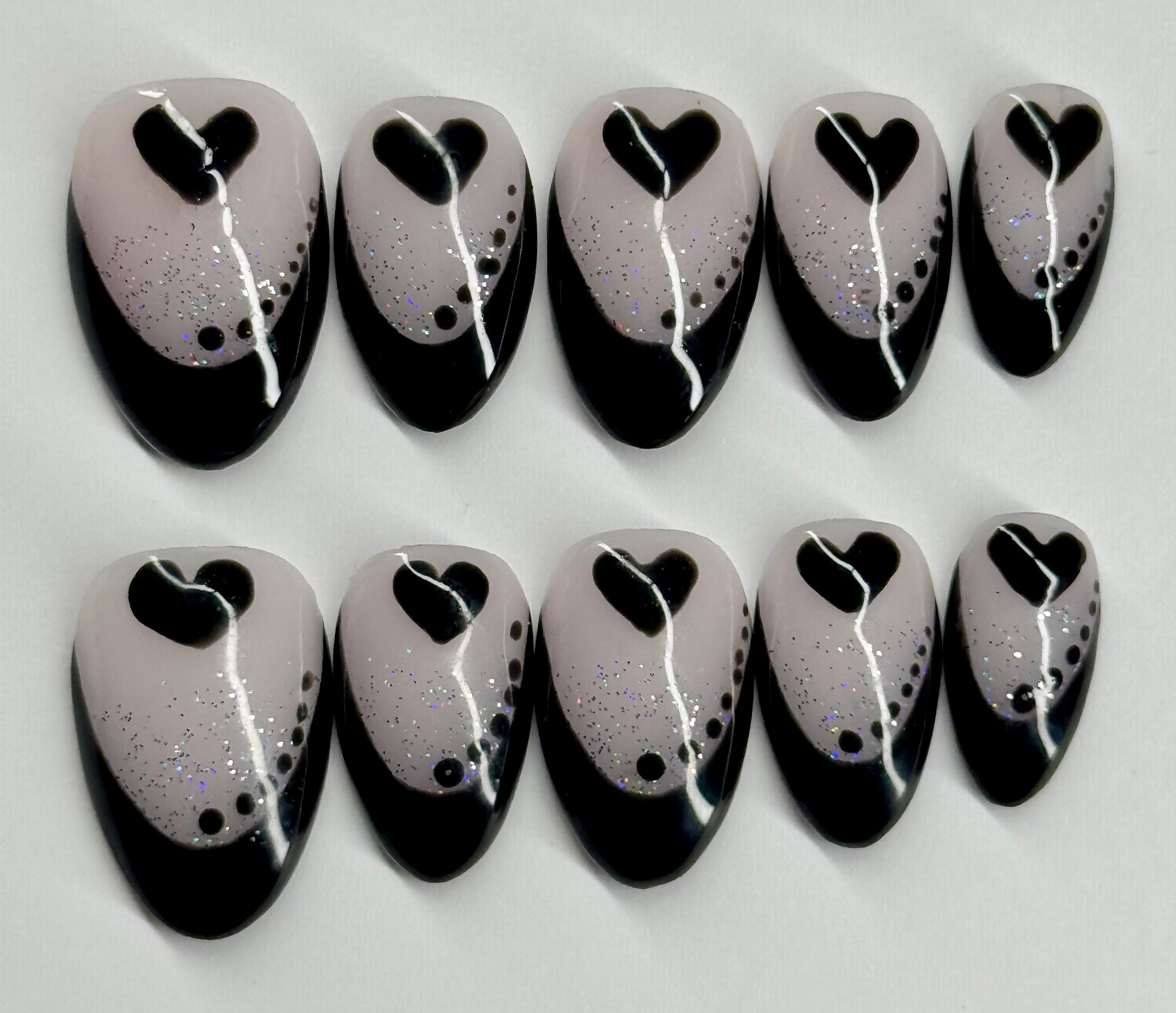 Set of black and white nail art designs on a light gray background