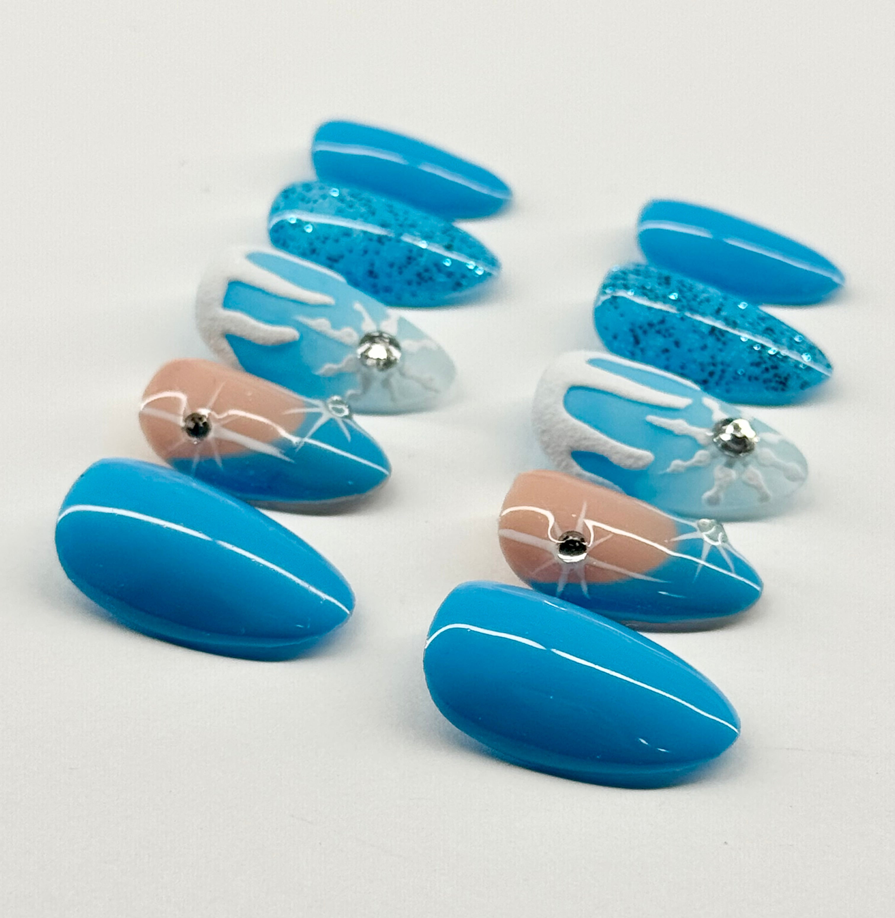 Set of blue and beige nail art designs on a white background