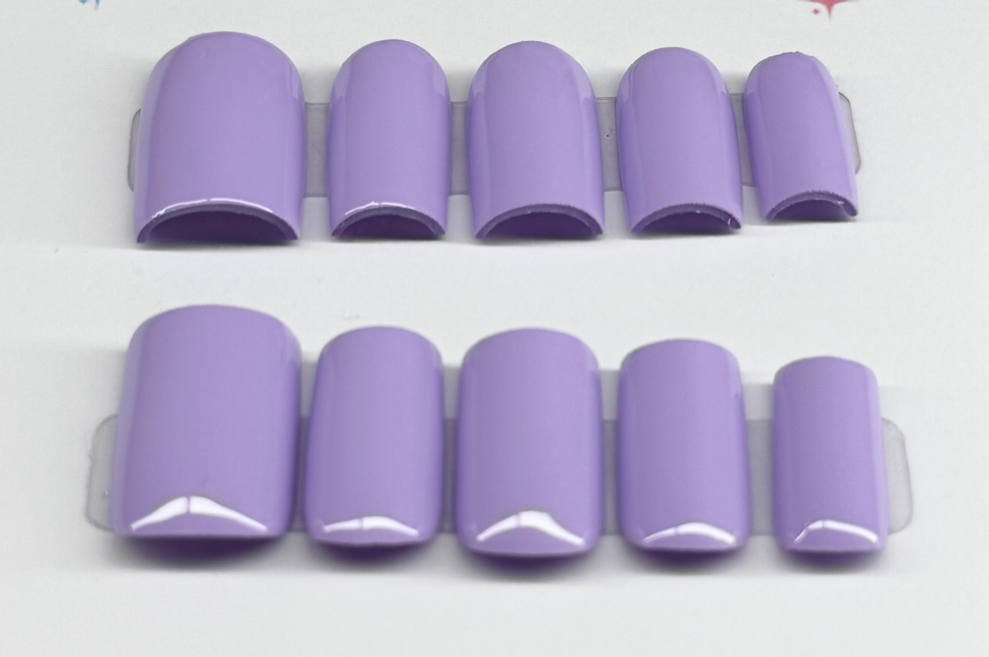 Set of purple nail tips on a white background