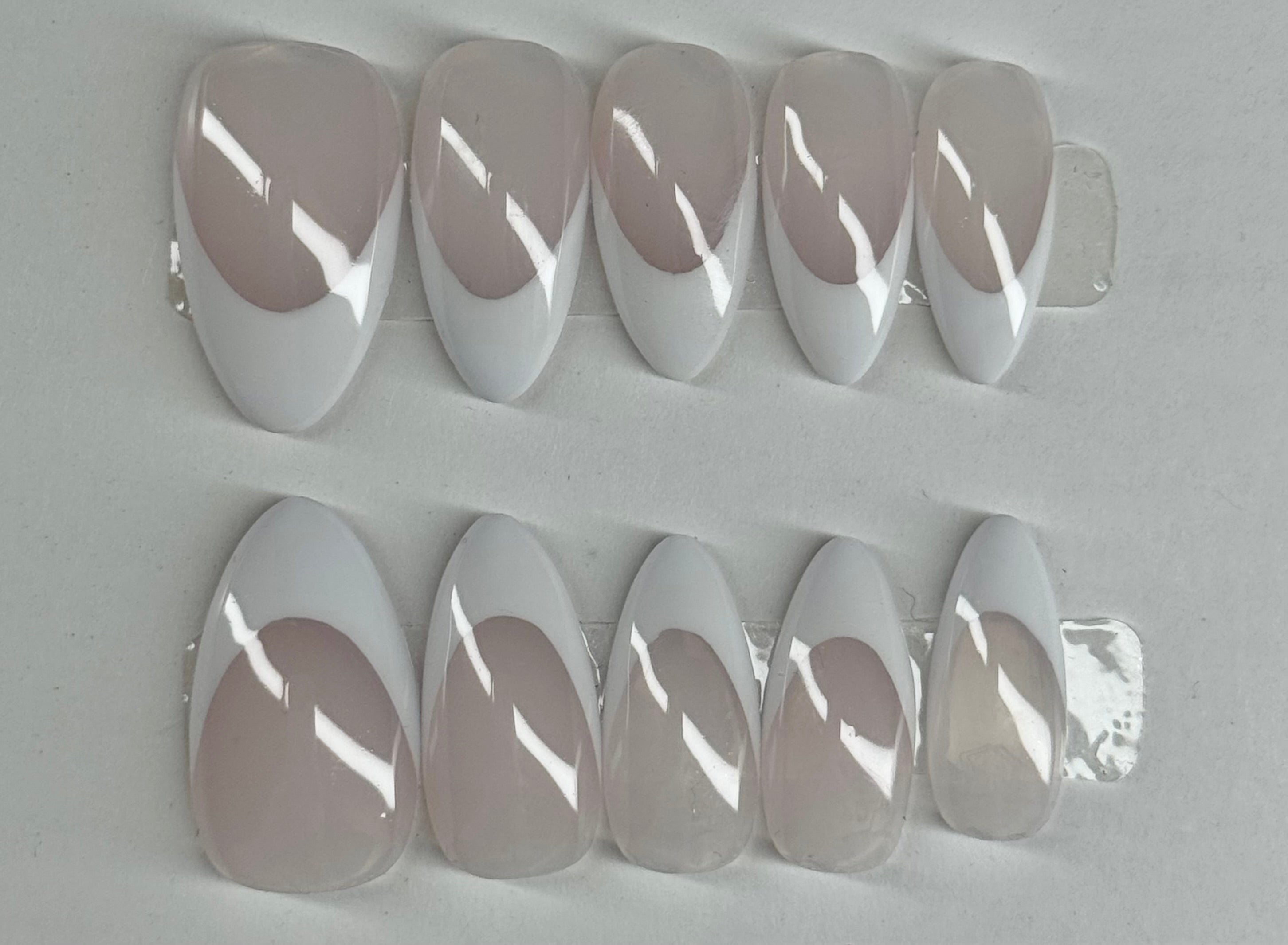 Set of clear nail extensions on a gray background
