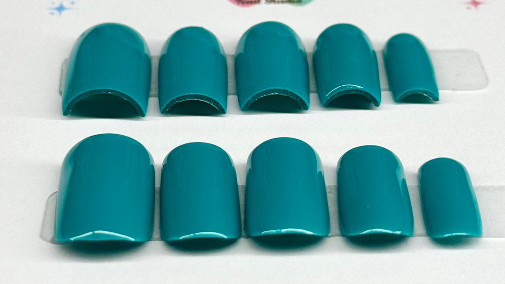 Set of teal nail tips on a white background