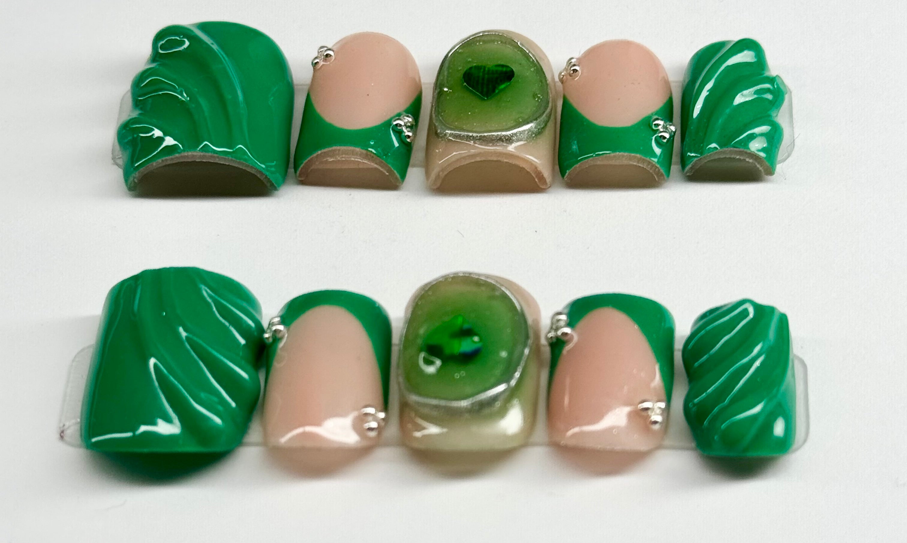 Set of green and beige ceramic beads on a white background