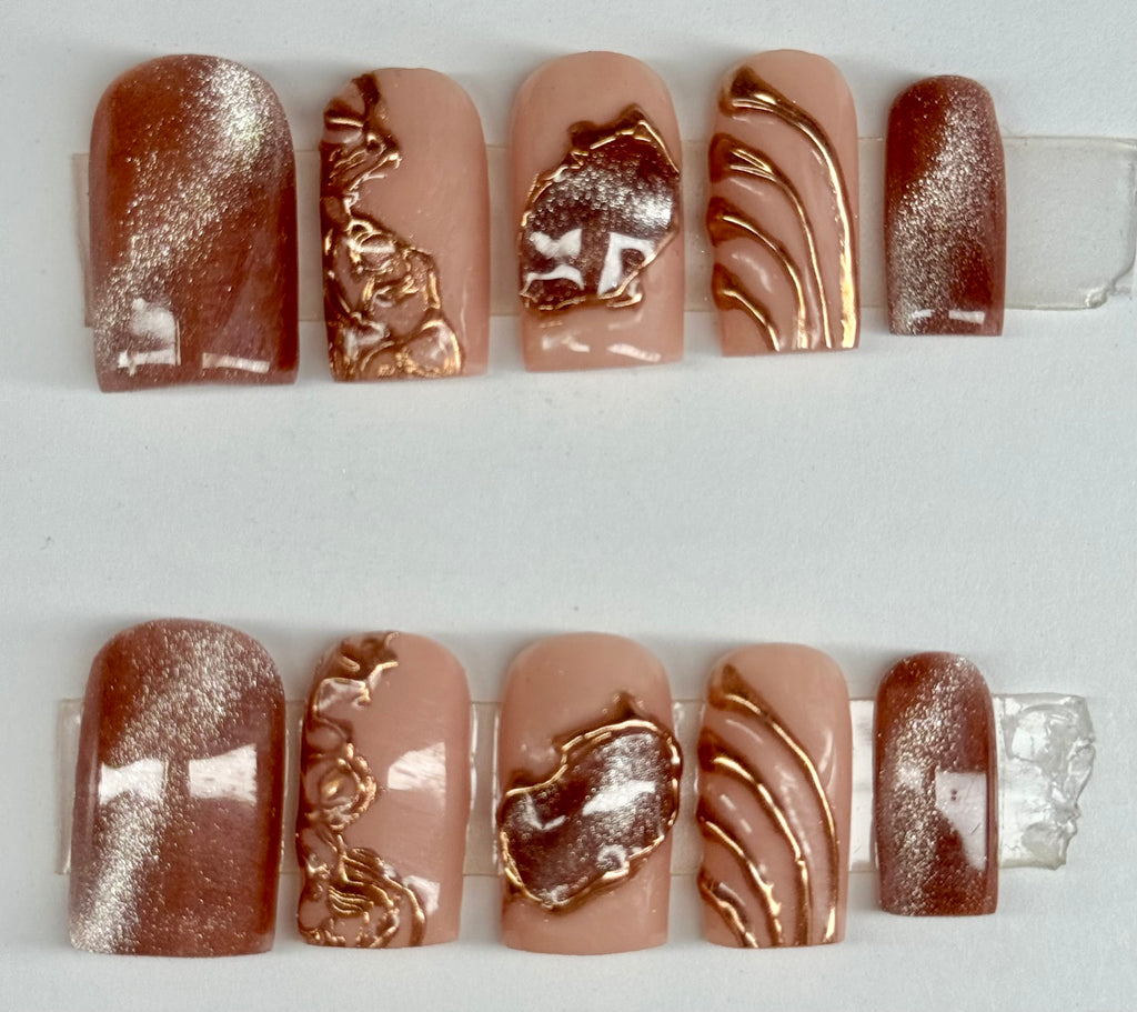 Set of nail designs with gold and silver accents on a white background