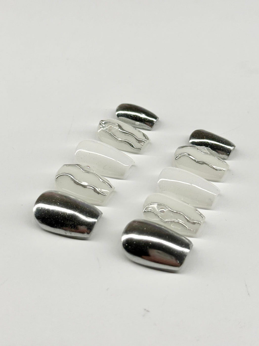 Silver ring with wavy design on a white background