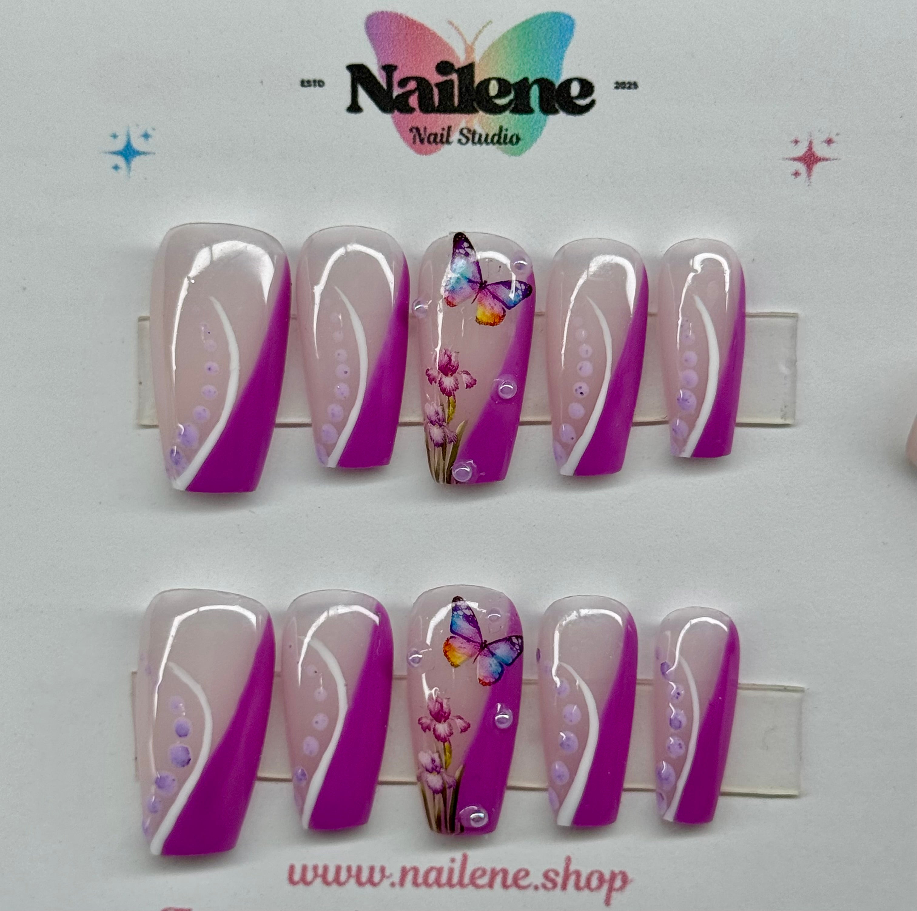 Set of decorative nails with purple and white designs on a white background, featuring the Nailene Nail Studio logo.