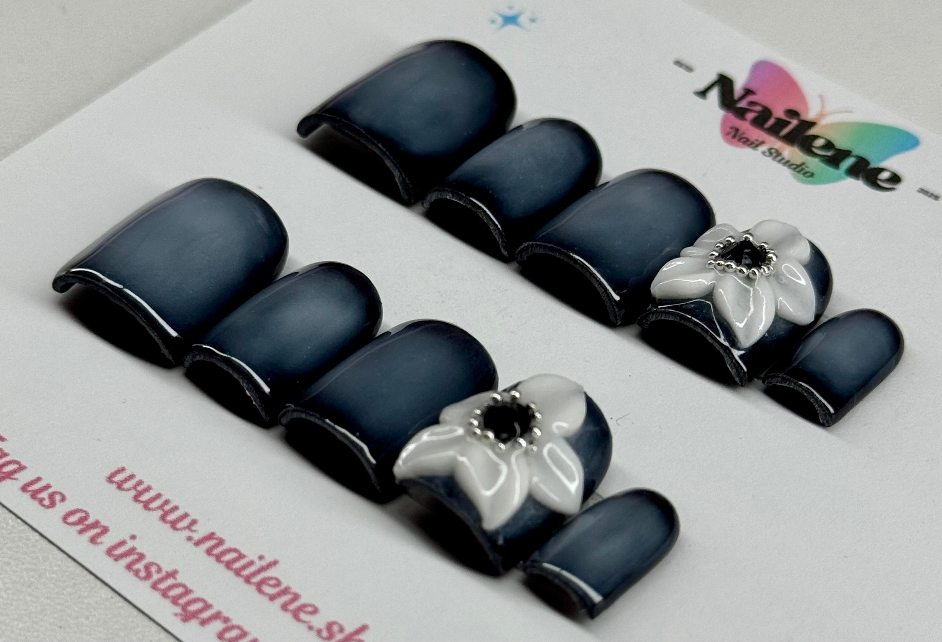 Black and white floral nail art design on a Nailene branded card.
