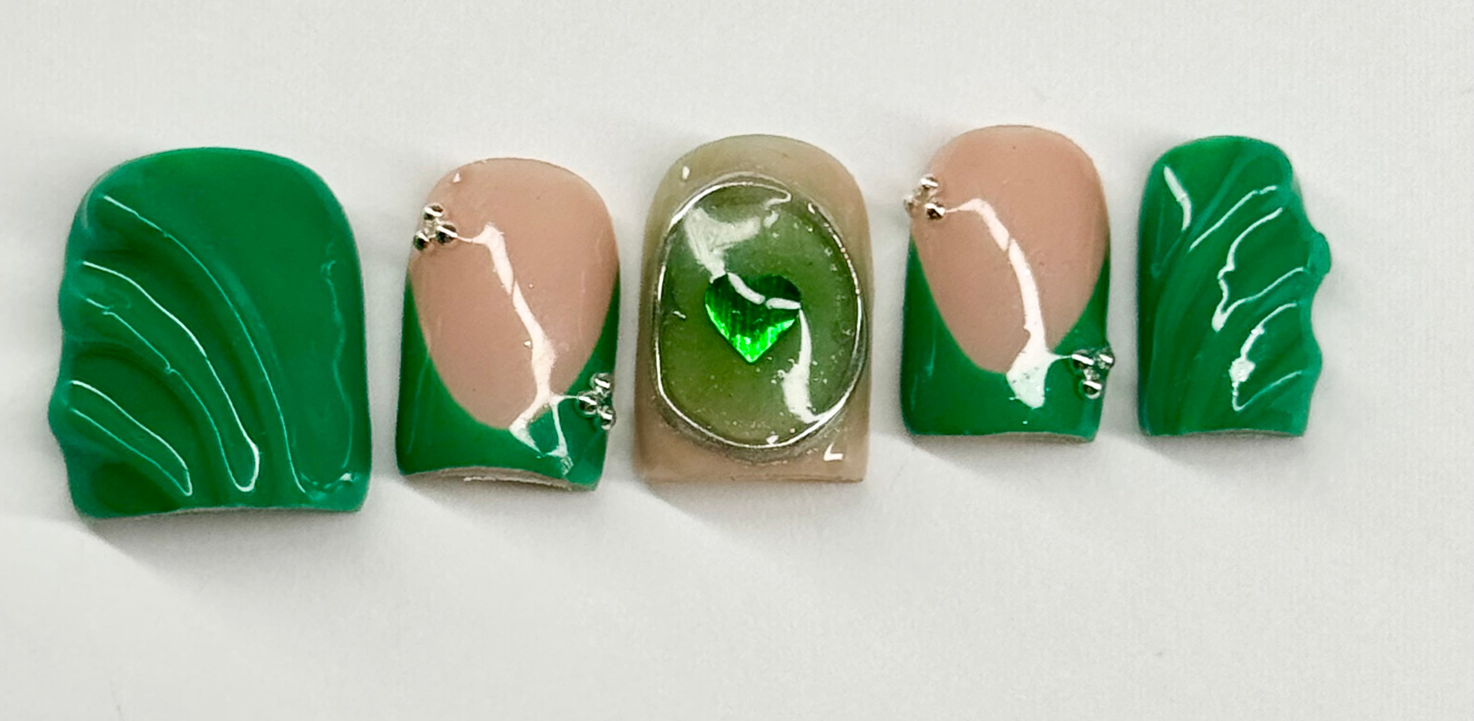 Five green and beige nail polish samples on a white background