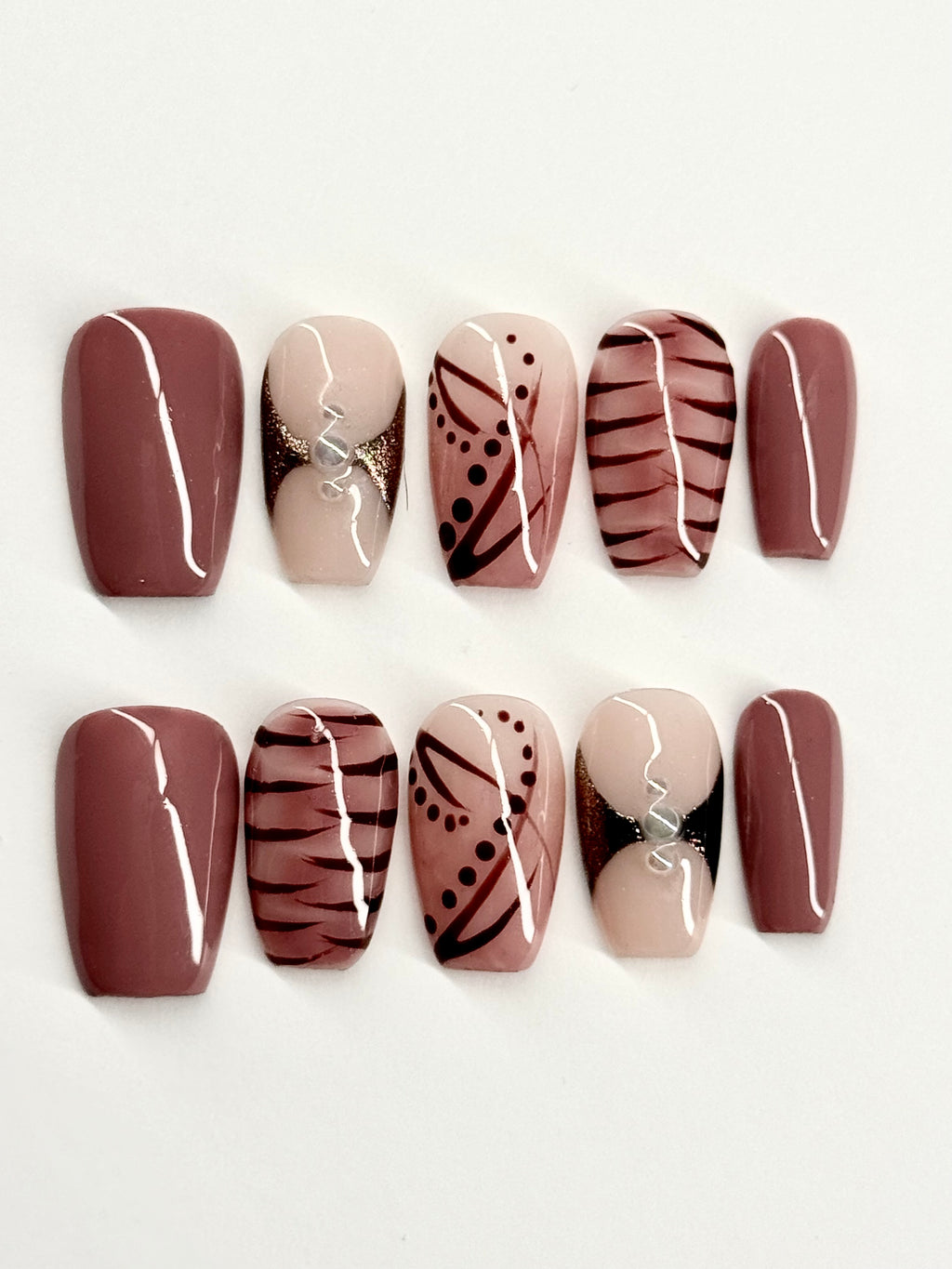 Set of nail designs with brown, beige, and black patterns on a white background