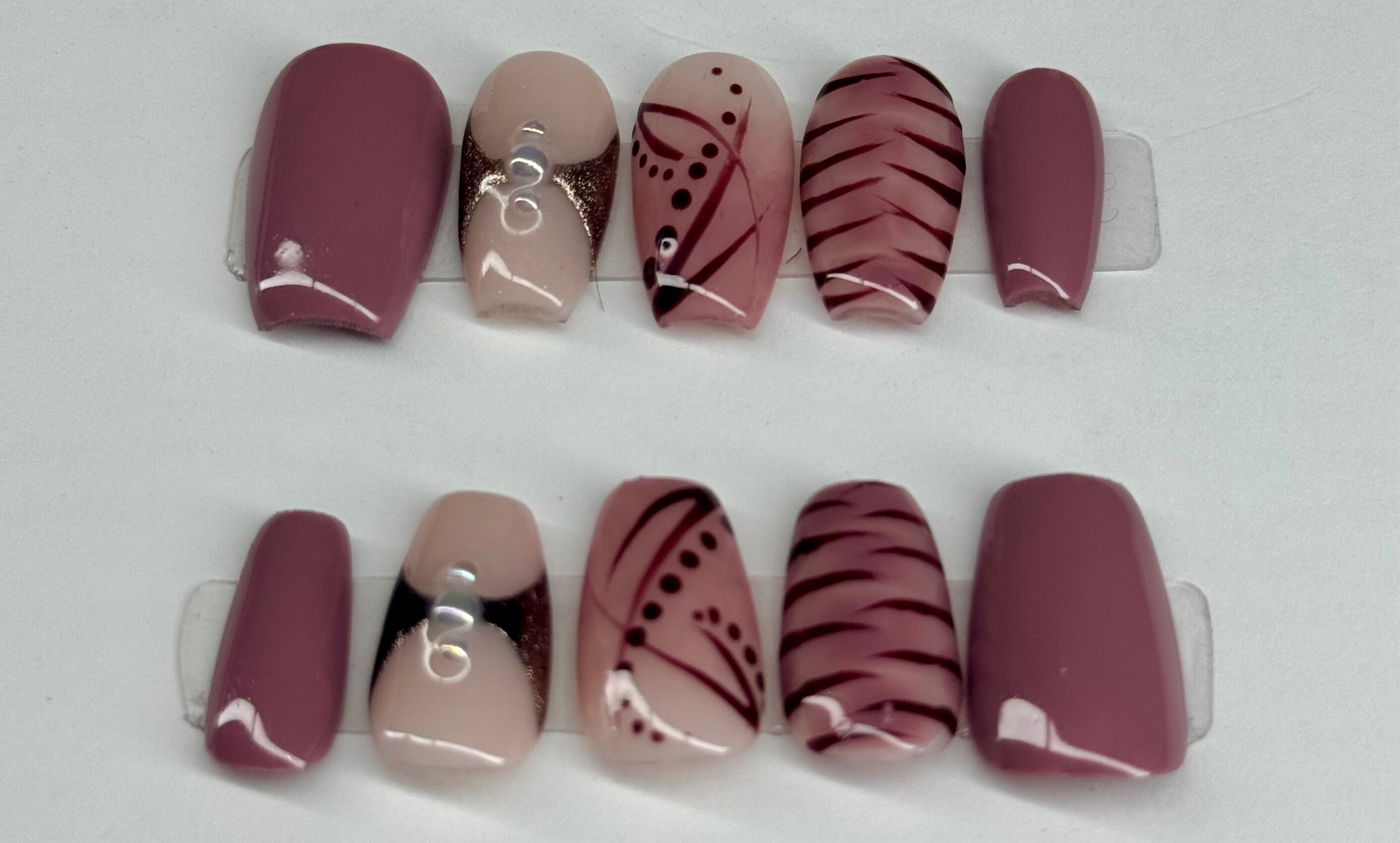 Set of nail wraps with various designs on a white background