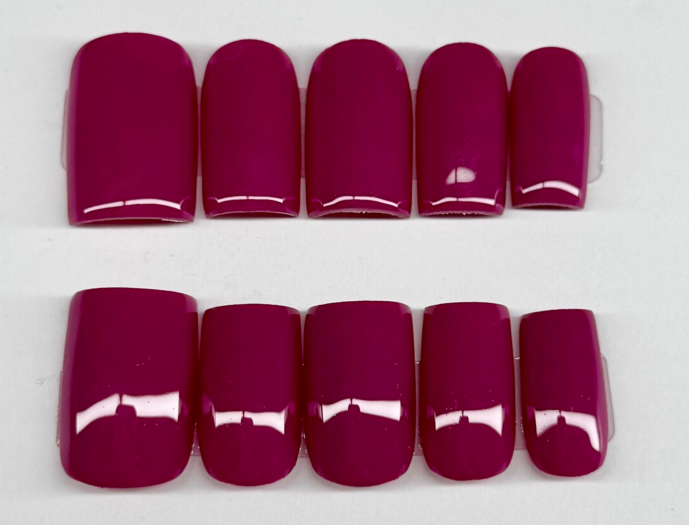 Set of plum solid color nail polish on a white background