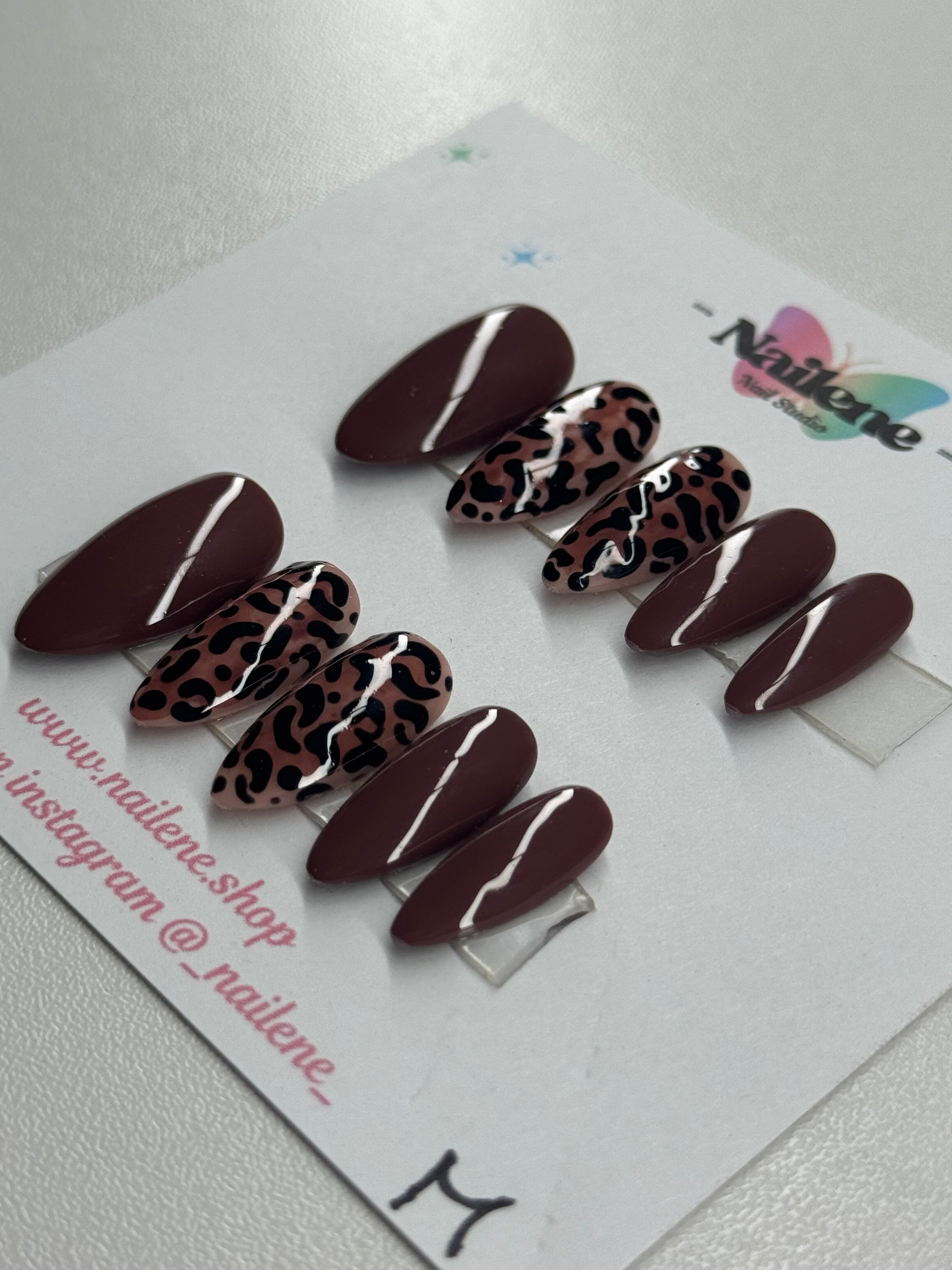 Set of brown and leopard print nails on a display card with Nailene branding.