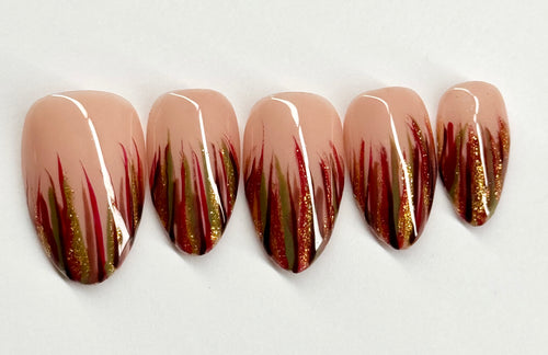 Set of five nails with a gradient design featuring brown, red, and gold on a white background