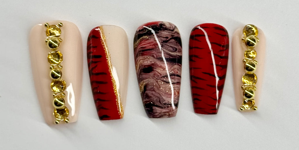 Five nail designs with gold accents on a white background