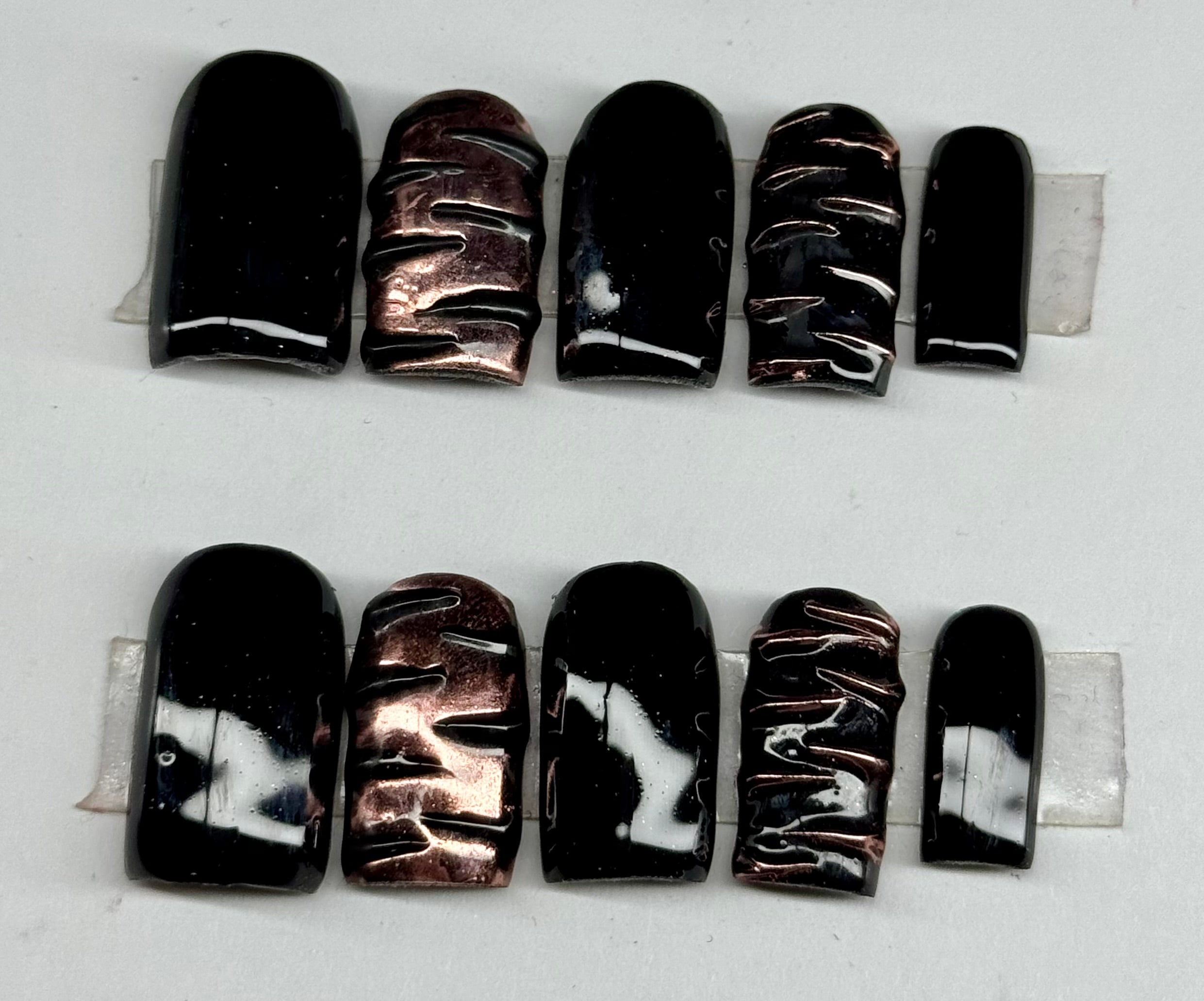 Row of black and silver marbled beads on a white background