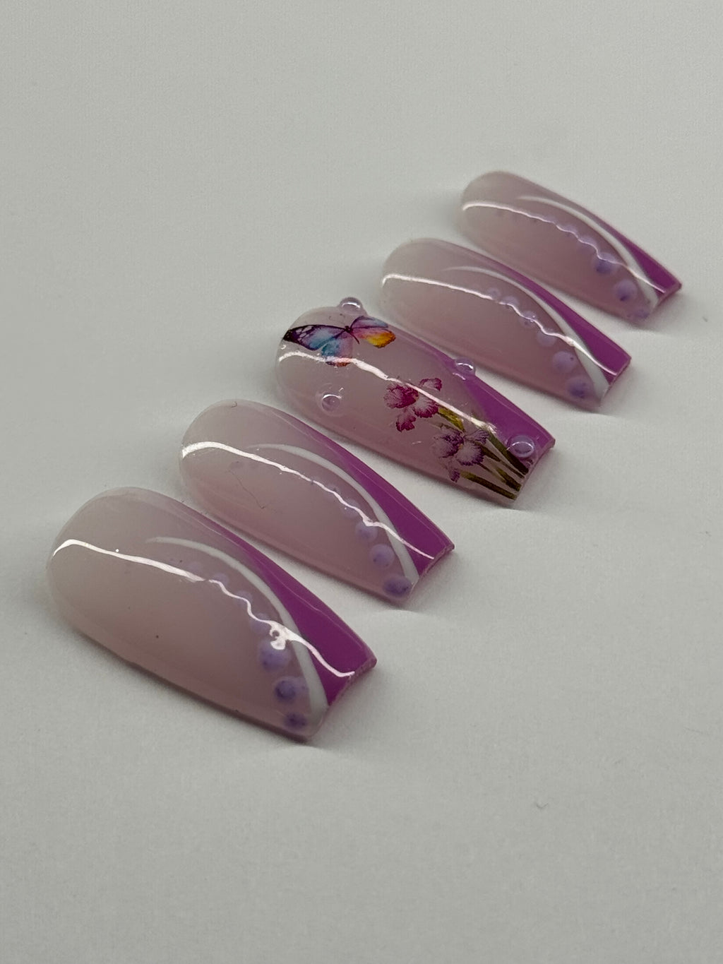 Set of purple and clear nail art designs on a white background
