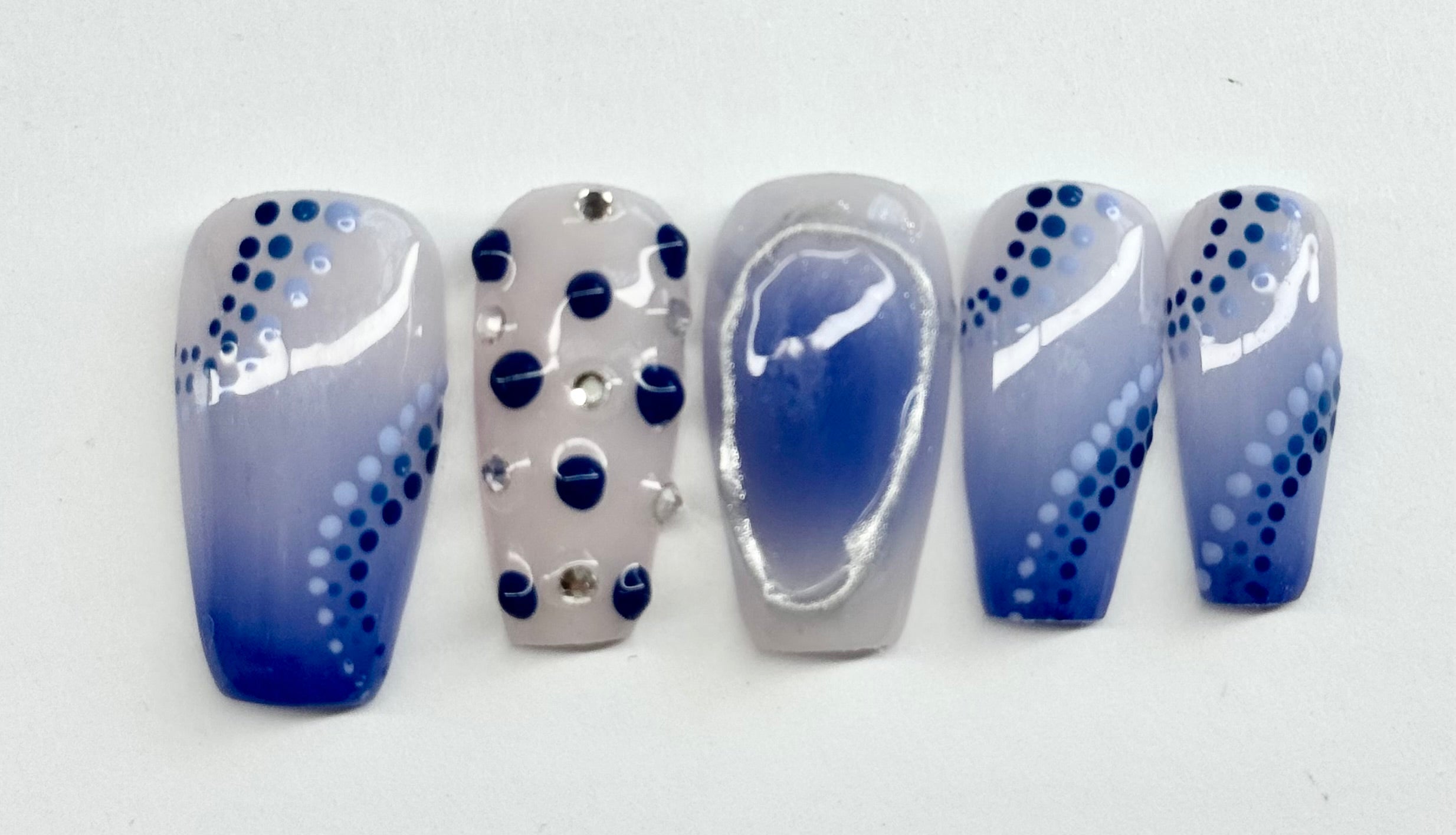 Set of blue and white nail art designs on a white background