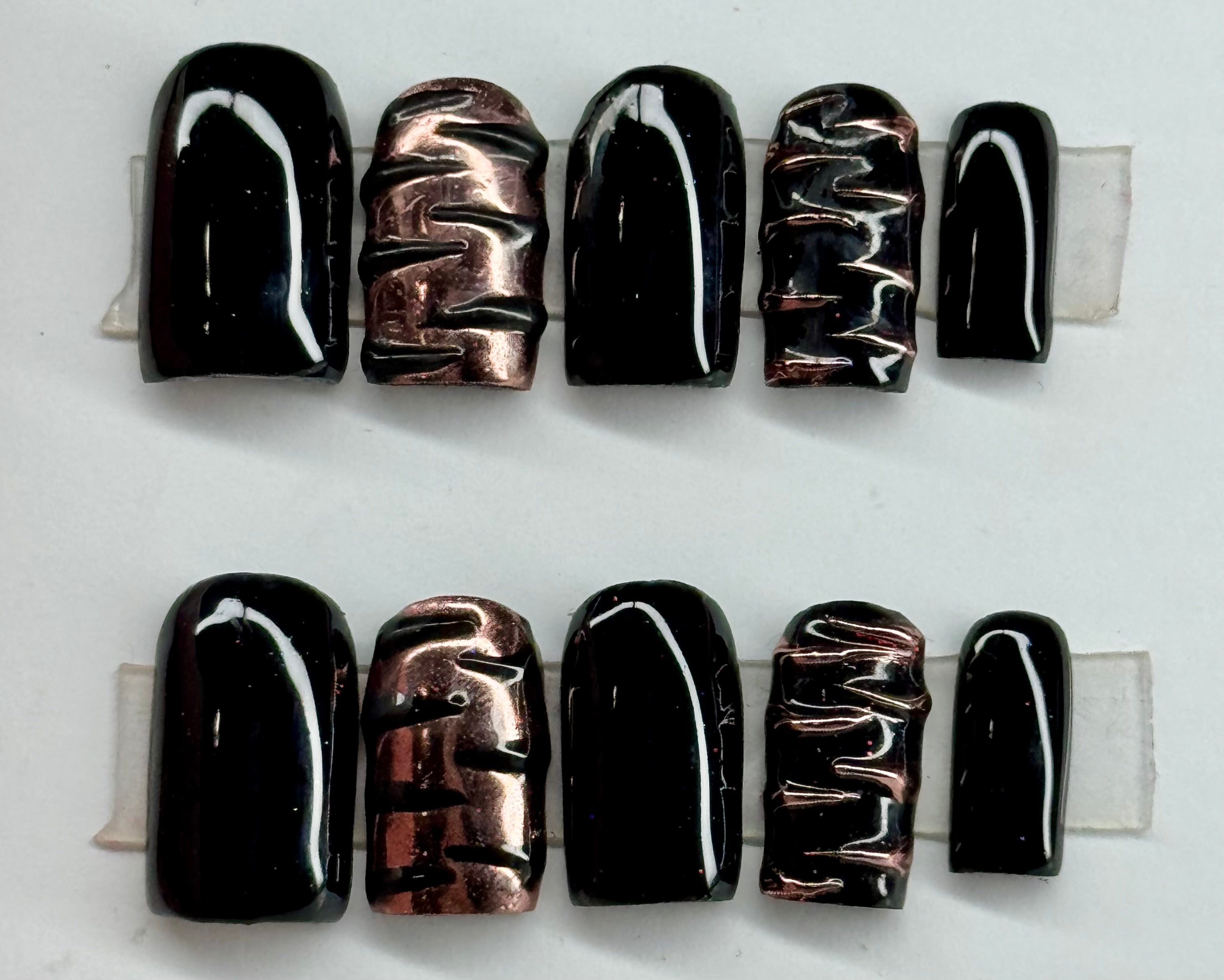 Set of black and copper nail art designs on a white background