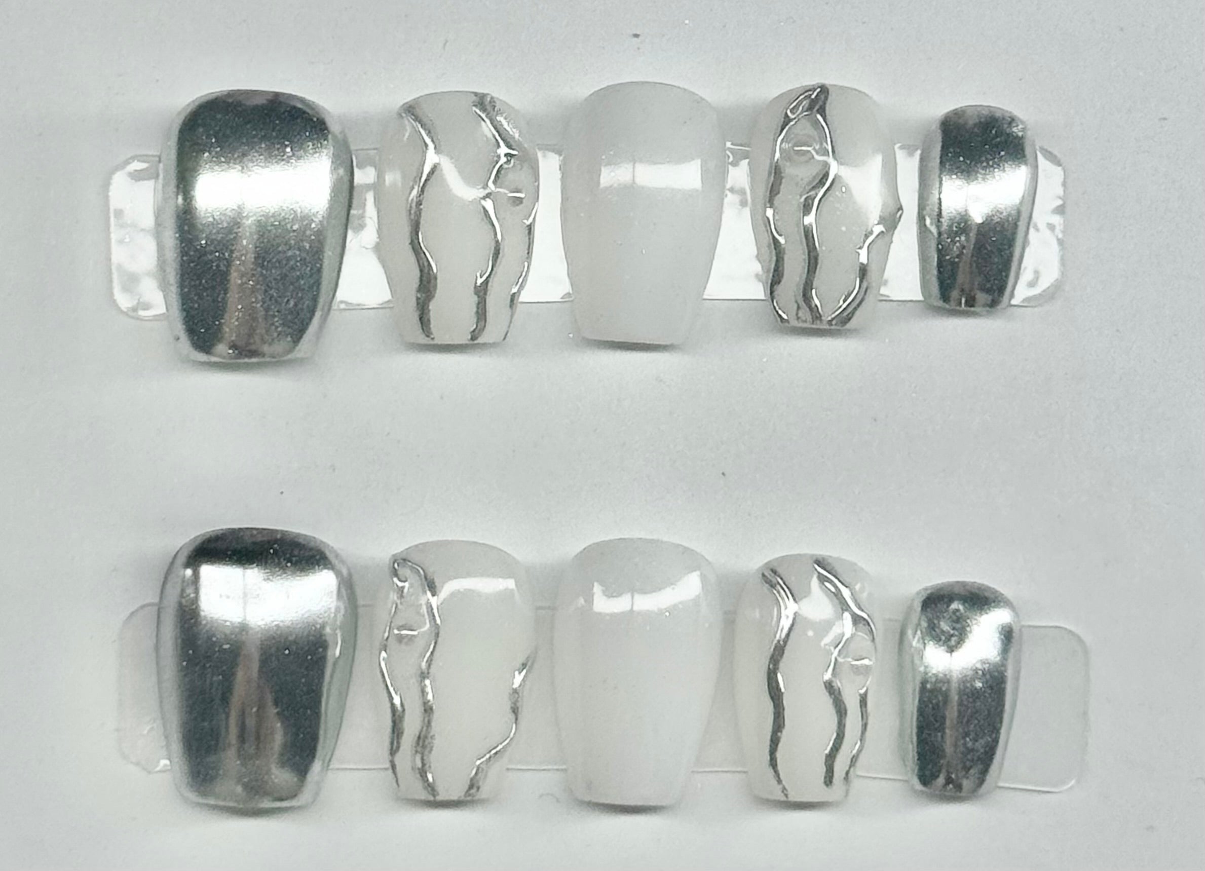 Set of silver hair clips with unique designs on a white background